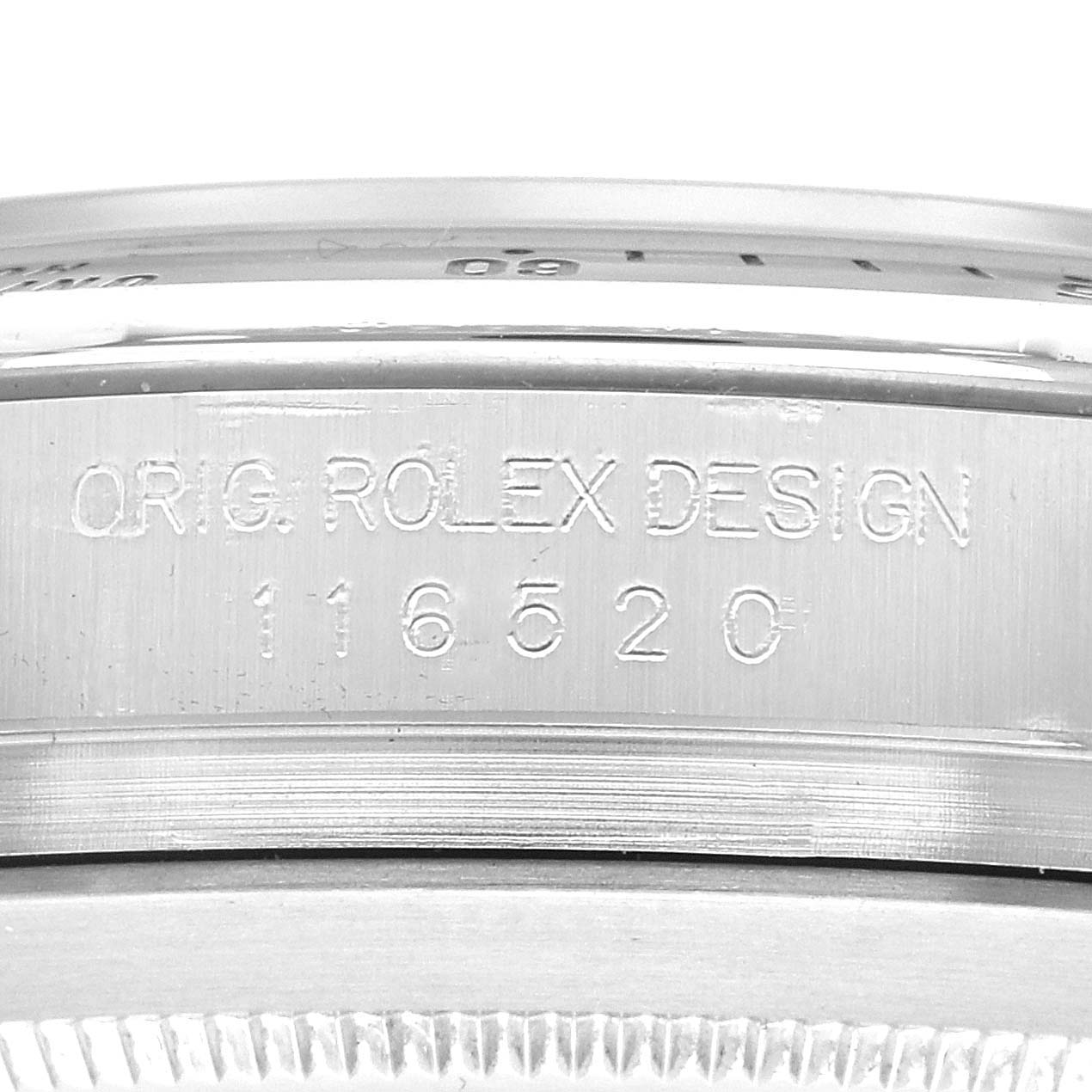 The image shows a close-up of the engraved side of the Rolex Daytona model 116520, focusing on the "ORIG. ROLEX DESIGN" and the model number engraving.