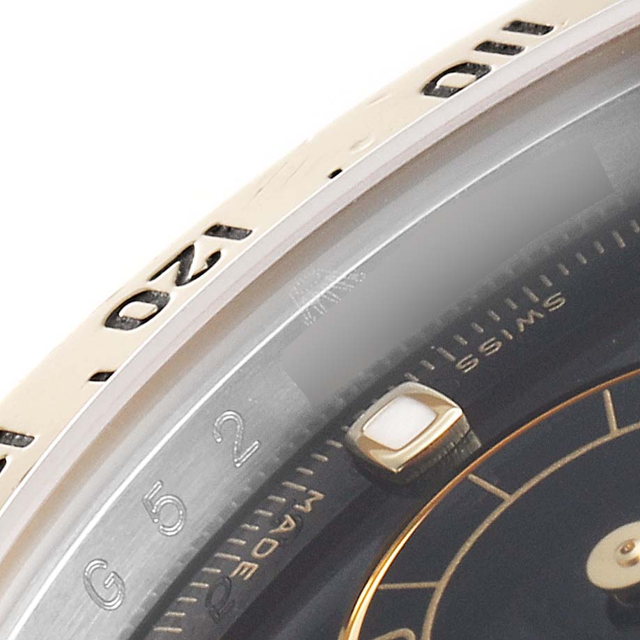 Close-up view of the bezel and part of the dial of a Rolex Daytona 116523 Men's Steel and Gold (two tone) Black Dial 116523 Men's Steel and Gold (two tone) Black Dial watch, showing the tachymeter scale and part of the hour markers.