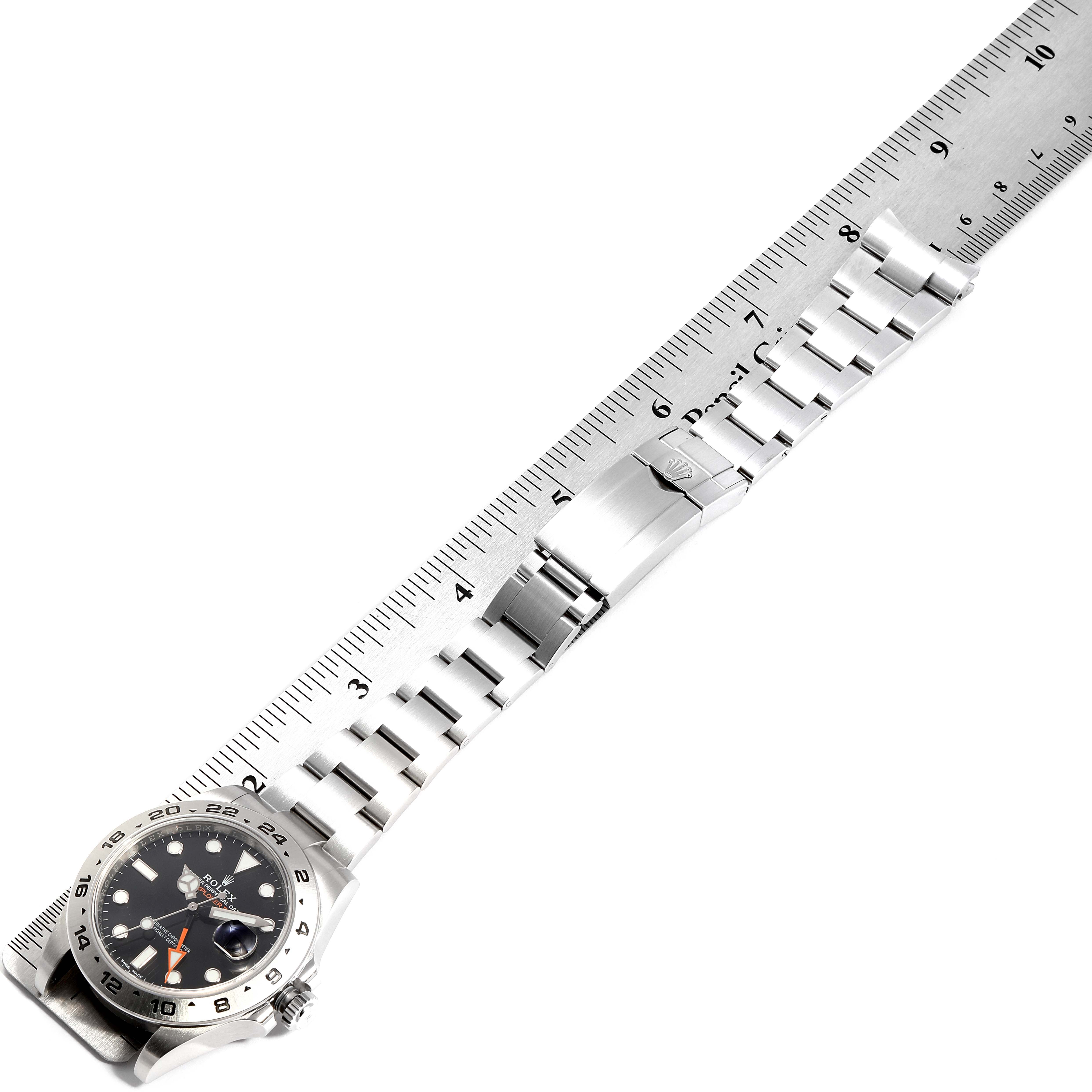 The image shows a side angle of a Rolex Explorer 216570 Men
s Stainless Steel Black Dial 216570 Men
s Stainless Steel Black Dial watch with its bracelet extended and aligned with a ruler.