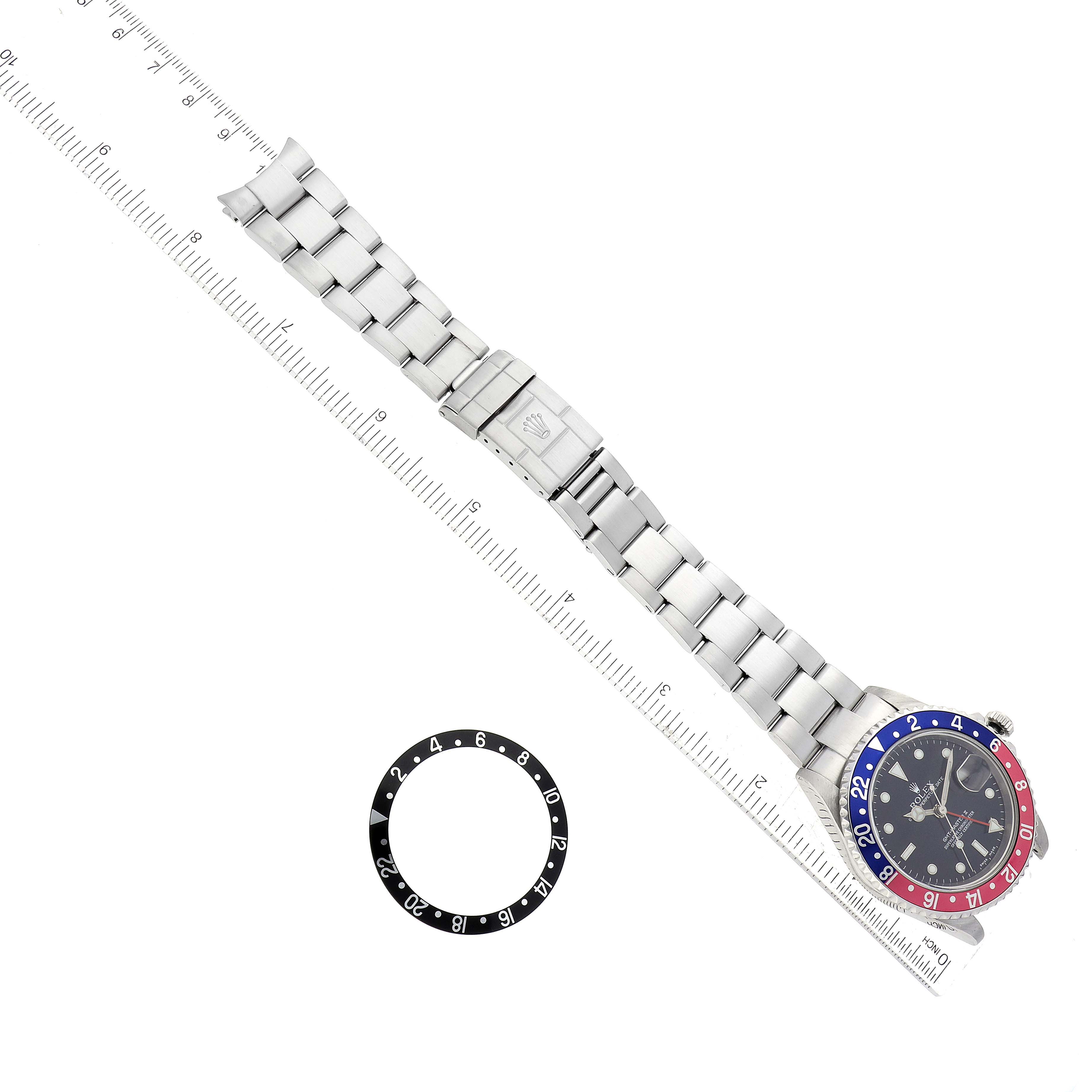 The image shows a Rolex GMT-Master 16710 Men's Stainless Steel Black Dial 16710 Men's Stainless Steel Black Dial watch laid flat with its bracelet fully extended, along with an extra bezel beside it.