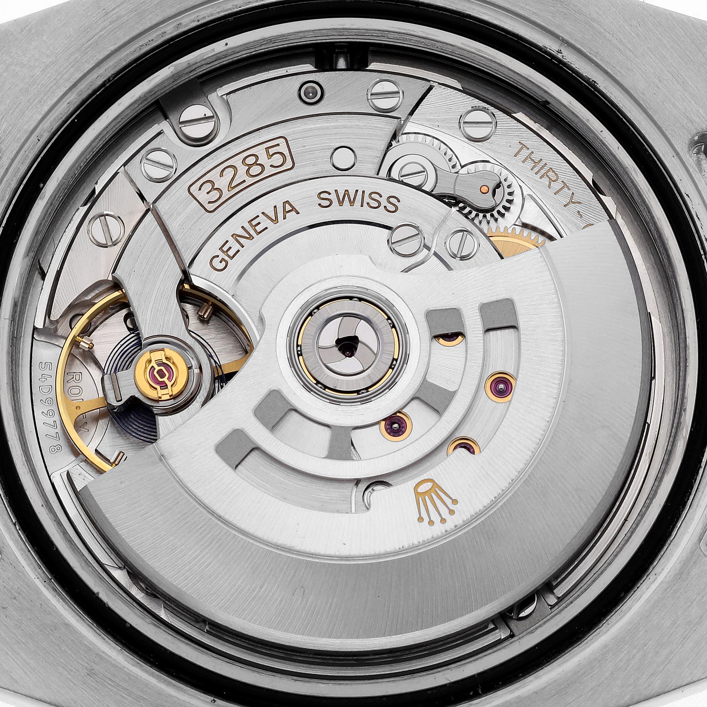 The image shows a close-up of the movement of a Rolex GMT-Master model 126711, highlighting the intricate components and engravings.