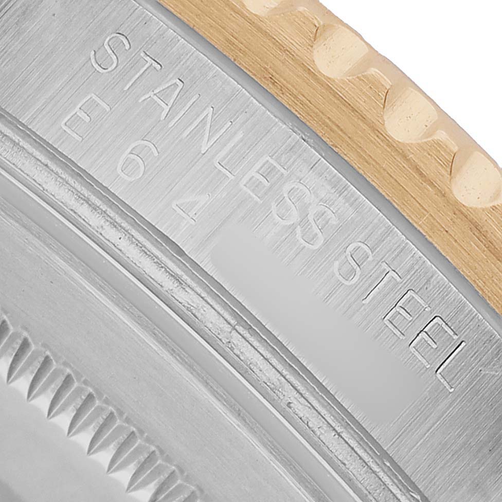 The image shows a close-up of the steel and gold bezel edge on a Rolex GMT-Master 16713 Men's Steel and Gold (two tone) Black Dial watch with engraved text.