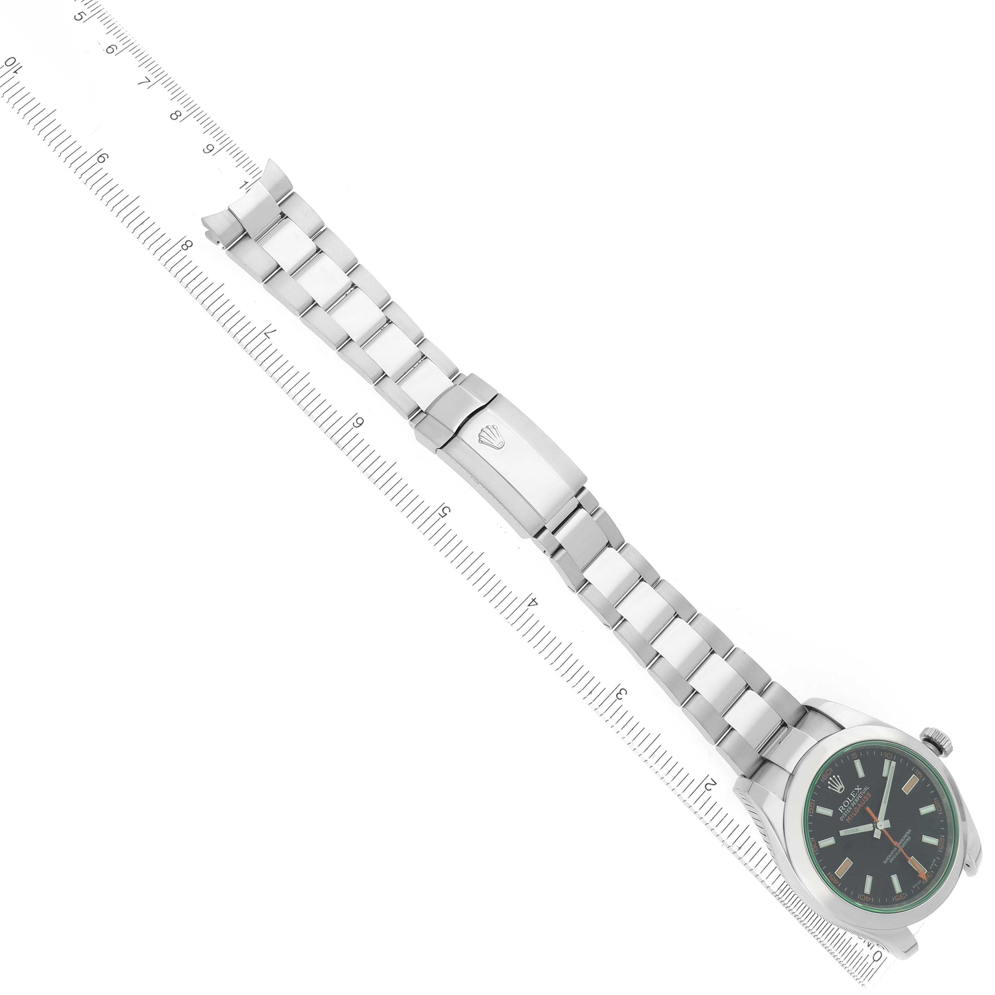 The image shows a Rolex Milgauss model 116400GV watch from a top-down angle, featuring the full bracelet, clasp, and the face with its distinctive green-tinted crystal.