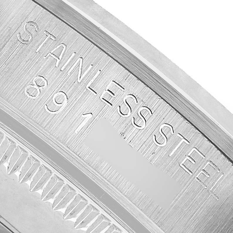 The image shows a close-up of the Rolex Mid-Size 67480 Women's Stainless Steel Silver Dial model case side, highlighting the stainless steel engraving.