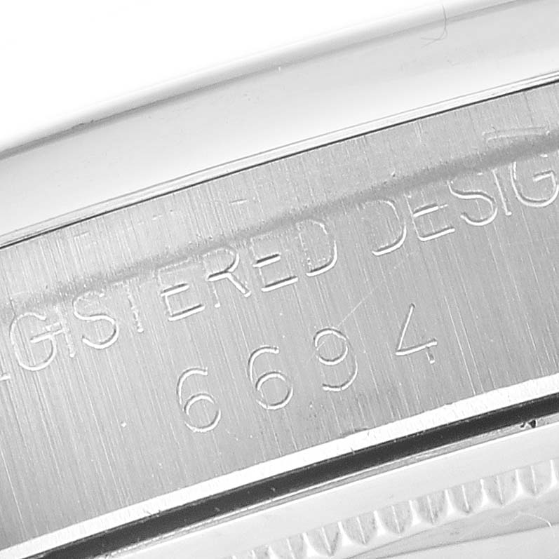 The image shows the engraved bezel and serial number of a Rolex Vintage Collection 6694 Men's Stainless Steel Champagne Dial model, viewed from the side.