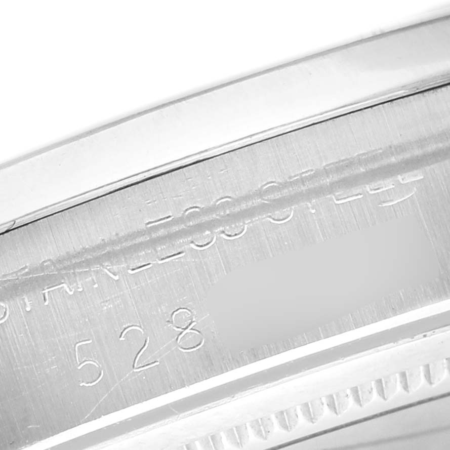 The image shows a close-up of the case edge and engraved serial number on a Rolex Vintage Collection 6694 Men's Stainless Steel Champagne Dial watch.