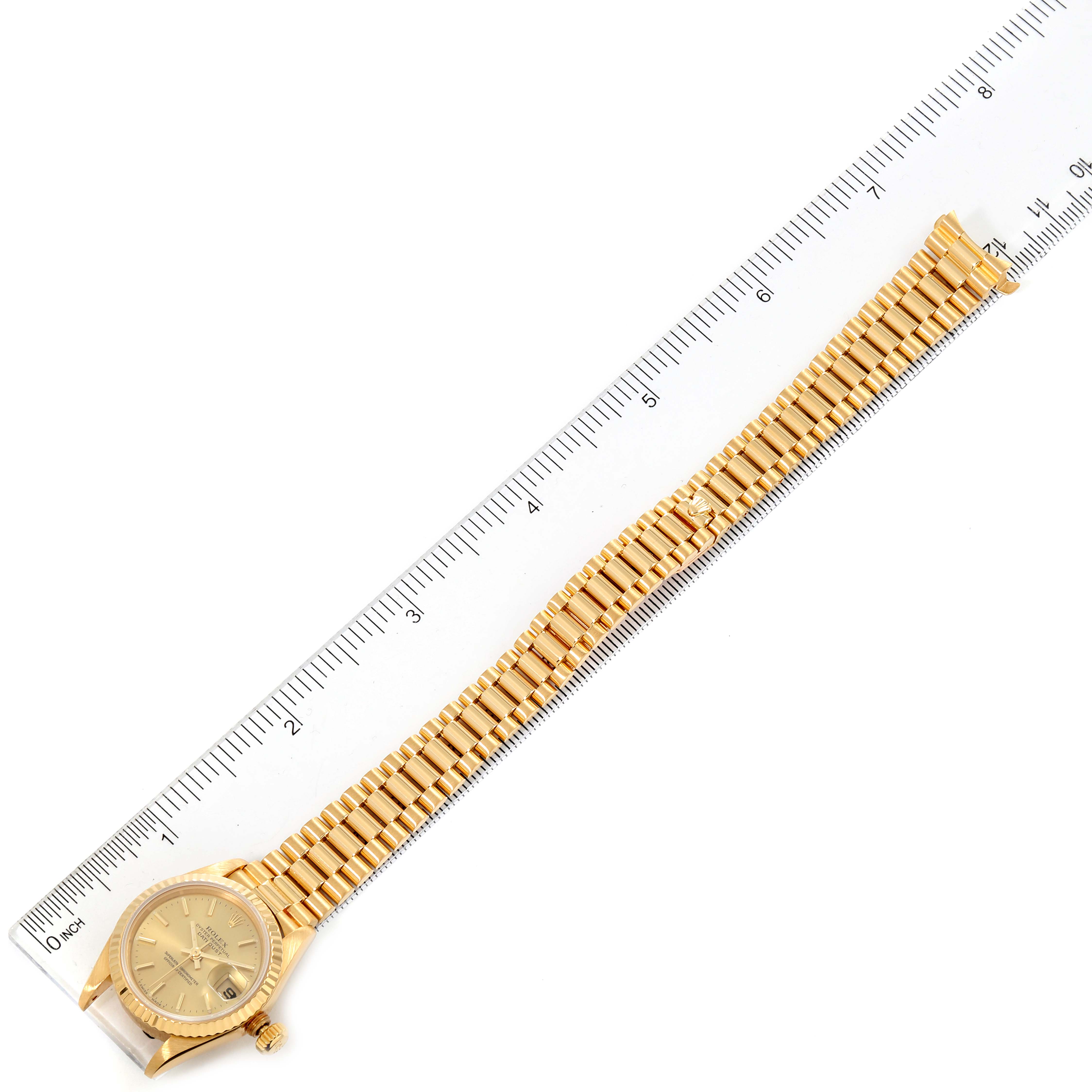 The Rolex President 69178 Women's Yellow Gold Champagne Dial 69178 Women's Yellow Gold Champagne Dial watch is shown from an overhead angle, displaying the full bracelet and face alongside a ruler.