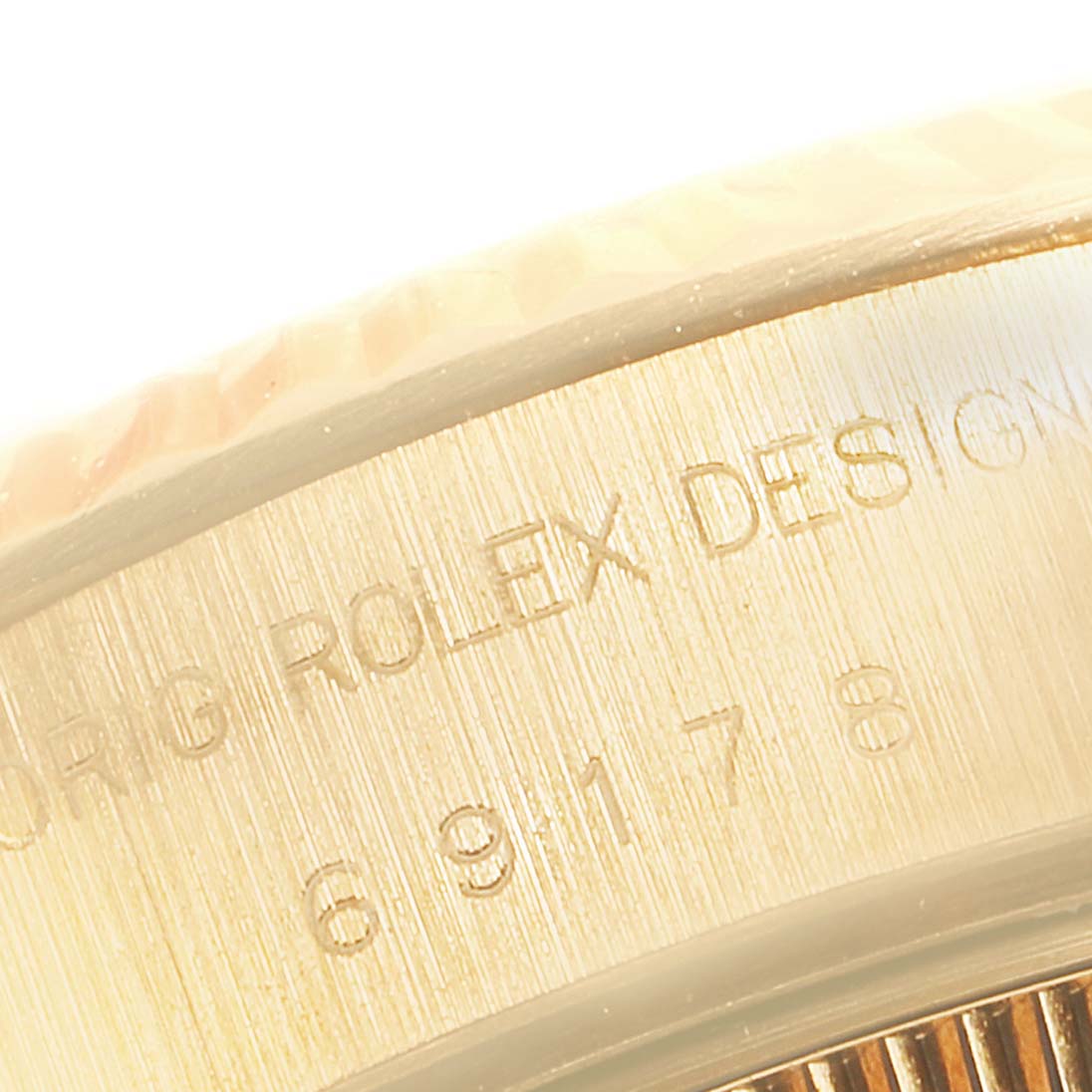 The image shows a detailed close-up of the side casing with engraved text of a Rolex President 69178 Women's Yellow Gold Champagne Dial 69178 Women's Yellow Gold Champagne Dial model watch.