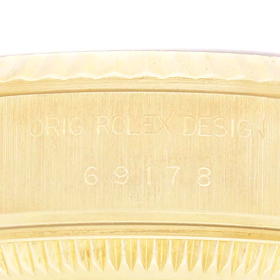This image shows a close-up side view of the bezel and engraved markings on a Rolex President 69178 Women's Yellow Gold Champagne Dial model watch.