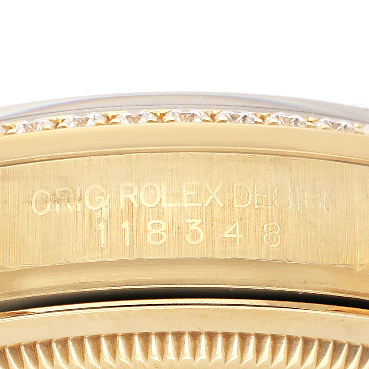 The image shows a close-up of the side of a Rolex President 118348 Men's Yellow Gold Mother of Pearl Dial model with engraving and diamond accents on the bezel.