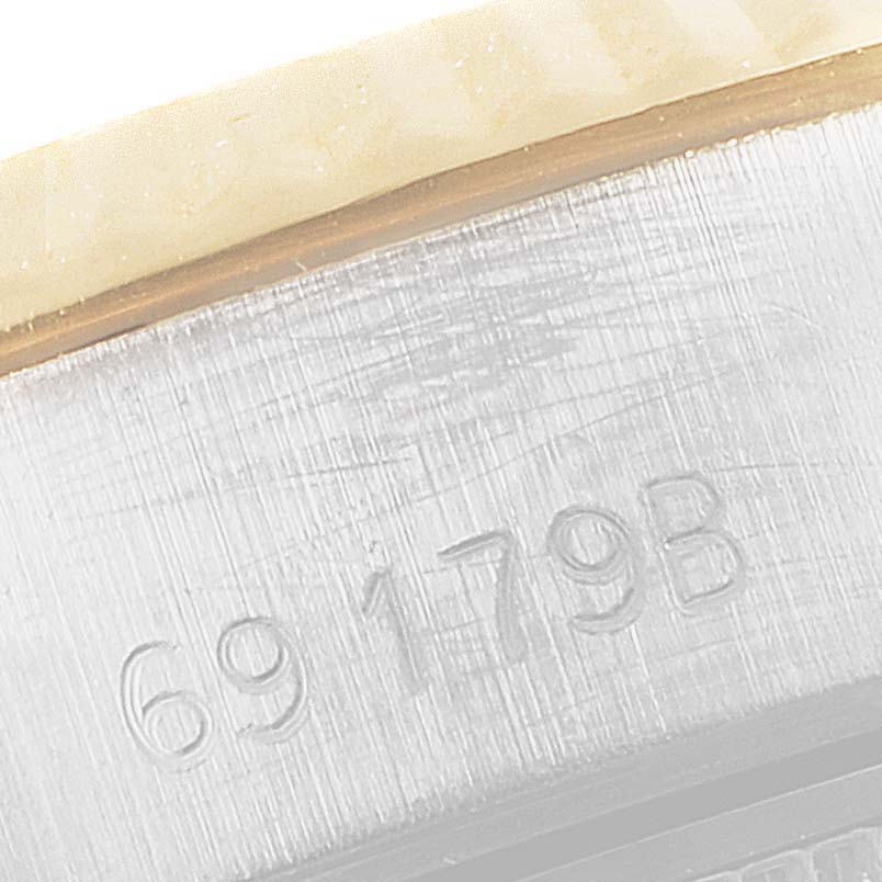 This close-up image shows the engraved serial number on a Rolex President 69179 Women's White Gold White Dial 69179 Women's White Gold White Dial model watch case.