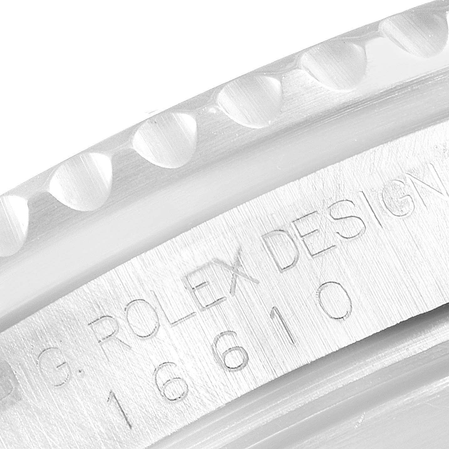 The image shows a close-up of the Rolex Submariner 16610 Men
s Stainless Steel Black Dial 16610 Men
s Stainless Steel Black Dial
s bezel and engraved reference number.