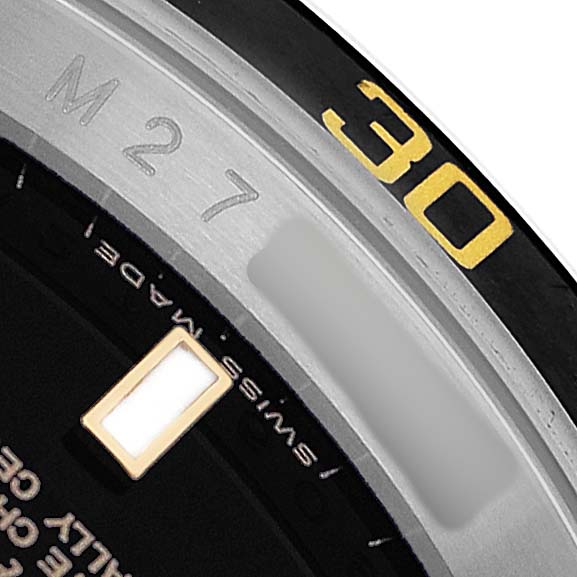 The image shows a close-up of a Rolex Submariner 16613LN Men's Steel and Gold (two tone) Black Dial's bezel and a portion of the dial.