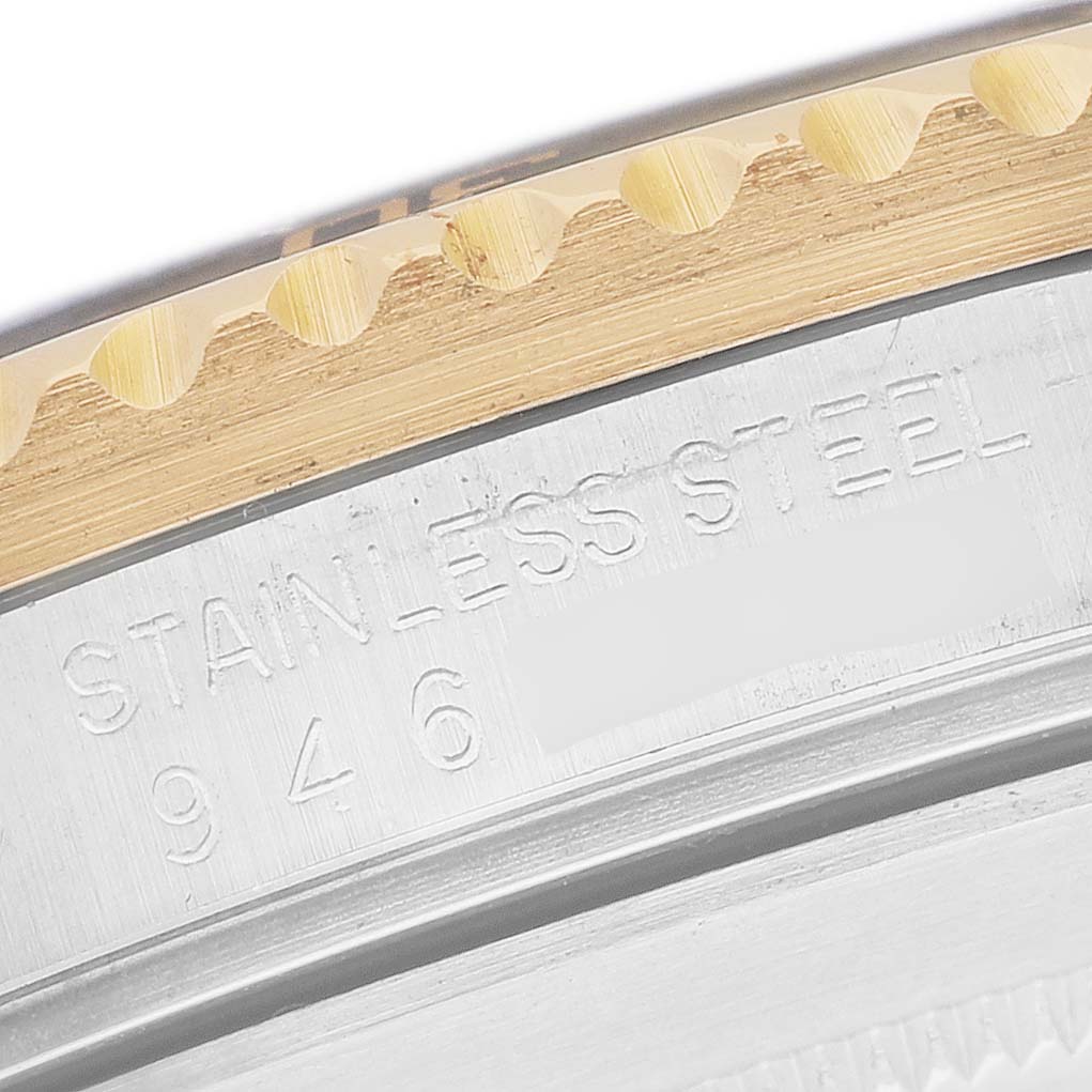 This image shows a close-up of the bezel and engraved side of a Rolex Submariner 16803 Men's Steel and Gold (two tone) Black Dial with focus on the text "STAINLESS STEEL."