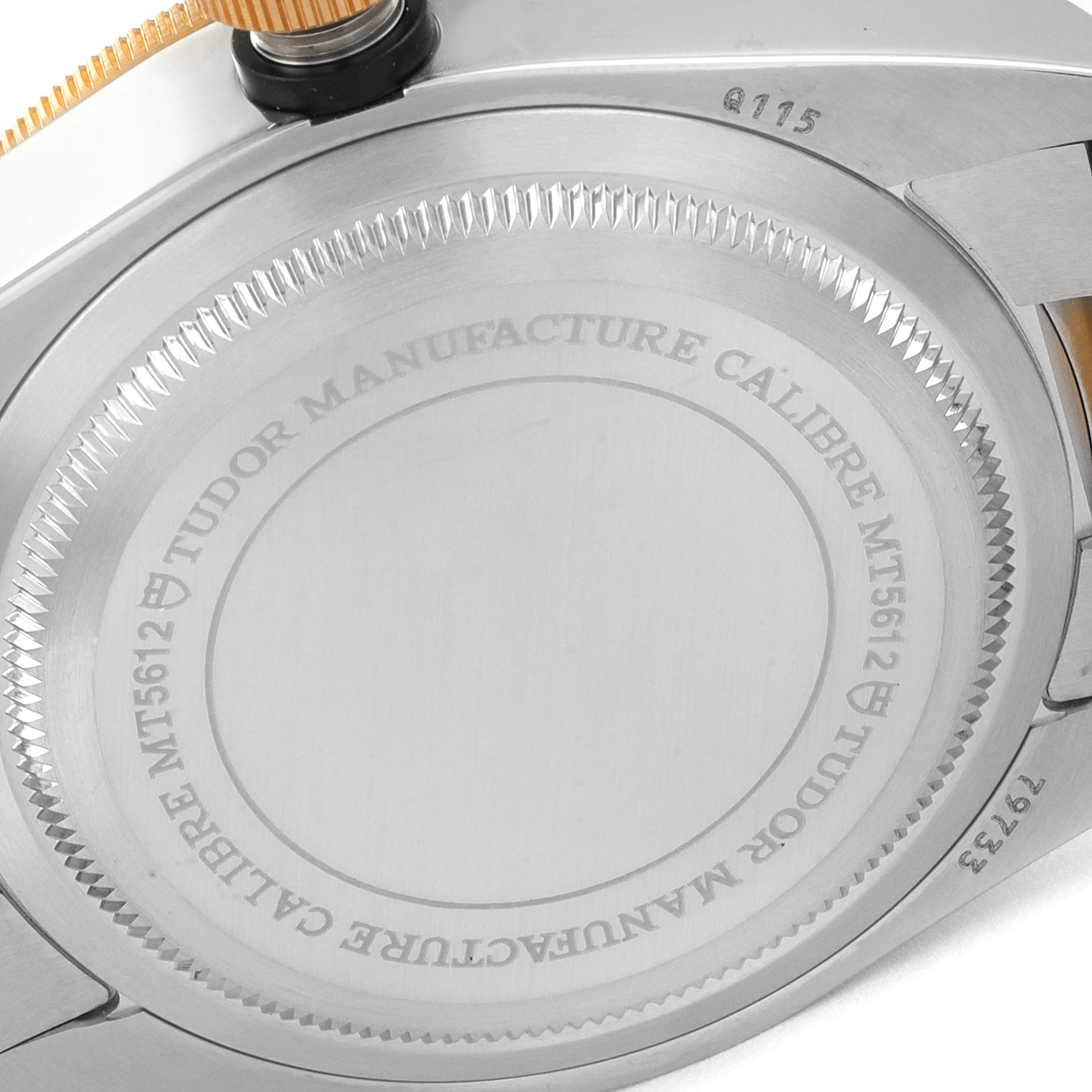The image shows a close-up of the case back of the Tudor Heritage Black Bay 79733 Men
s Steel and Gold (two tone) Black Dial 79733 Men
s Steel and Gold (two tone) Black Dial watch, highlighting the engravings and crown.