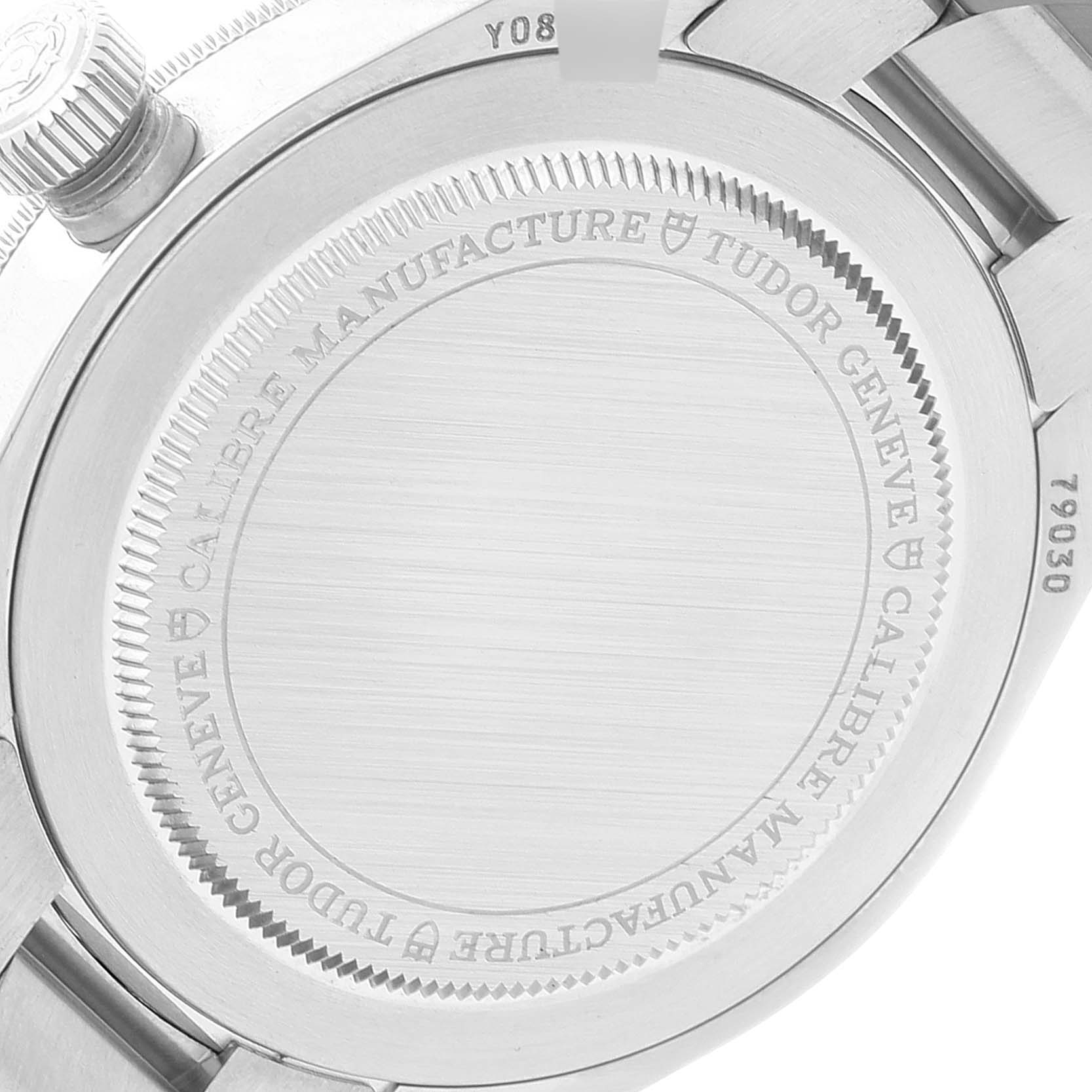 The image depicts the back case of a Tudor Heritage Black Bay 79030B Men's Stainless Steel Blue Dial 79030B Men's Stainless Steel Blue Dial watch, showcasing the engraved details and parts of the bracelet.