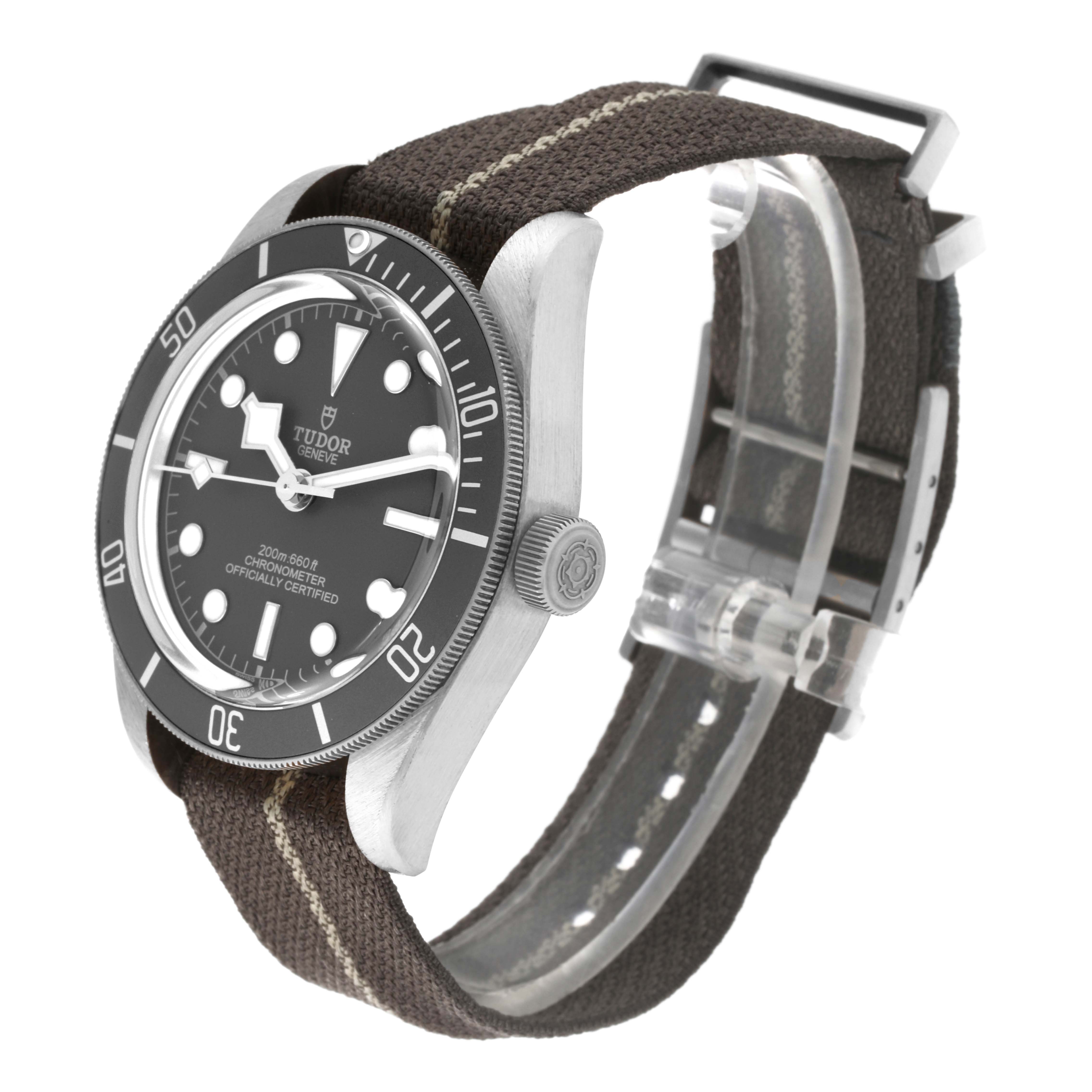 The Tudor Heritage Black Bay M79010SG-0002 Men's Stainless Steel Grey Dial M79010SG-0002 Men's Stainless Steel Grey Dial watch is shown at a three-quarter angle, highlighting the dial, bezel, case, crown, and fabric strap.