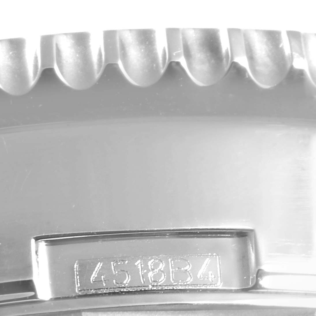 This image shows a close-up of the side of a Breitling Navitimer AB0127211C1A1 Men's Stainless Steel Blue Dial AB0127211C1A1 Men's Stainless Steel Blue Dial watch, highlighting the bezel and part of the case with an engraved serial number.