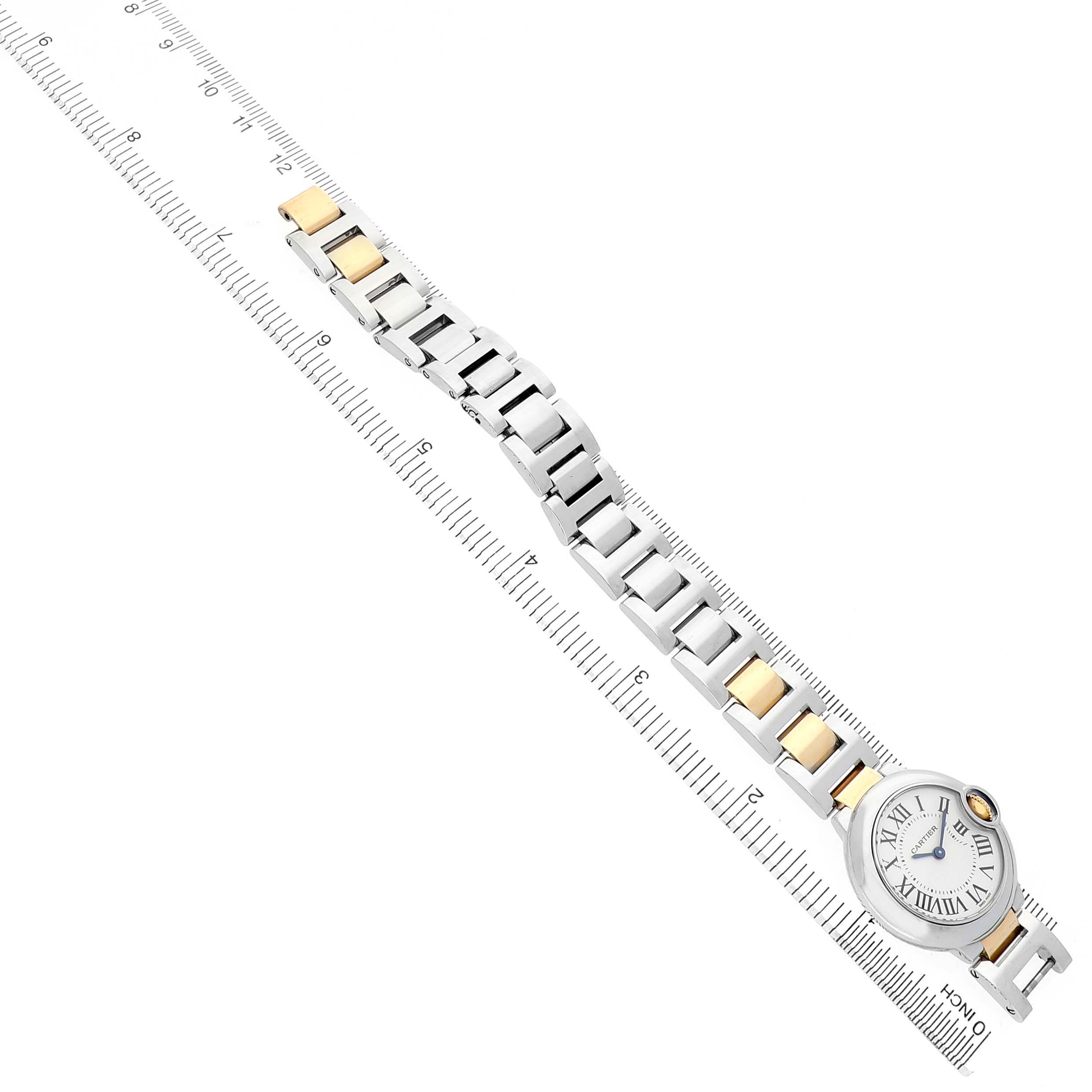 The Cartier Ballon Bleu W69007Z3 Women's Steel and Gold (two tone) Silver Dial watch is shown at an angled view, displaying its round face and two-tone bracelet aligned next to a ruler.