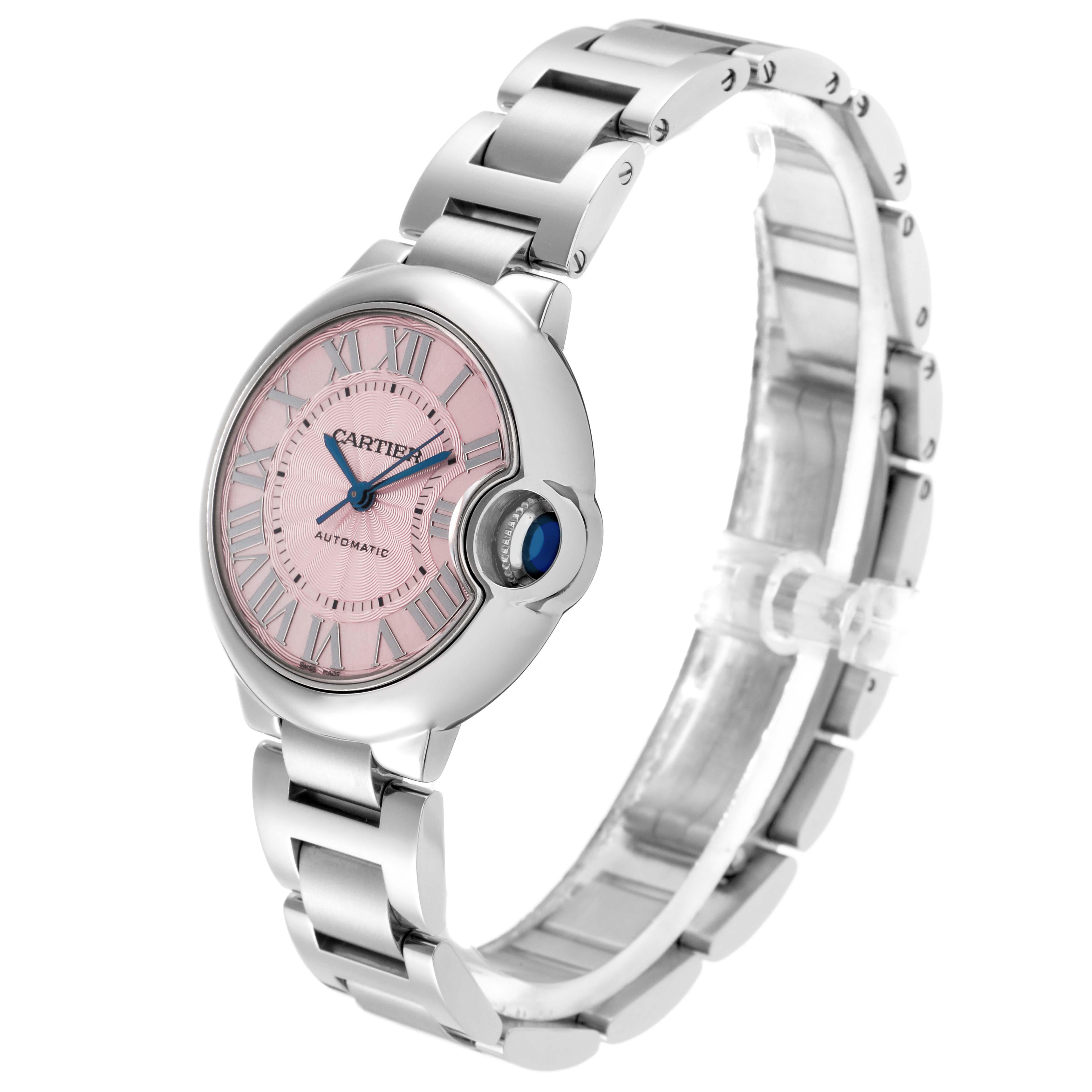 The Cartier Ballon Bleu W6920100 Women
s Stainless Steel Pink Dial W6920100 Women
s Stainless Steel Pink Dial watch is shown at a three-quarter angle, displaying its pink dial, Roman numerals, blue hands, and metal bracelet.
