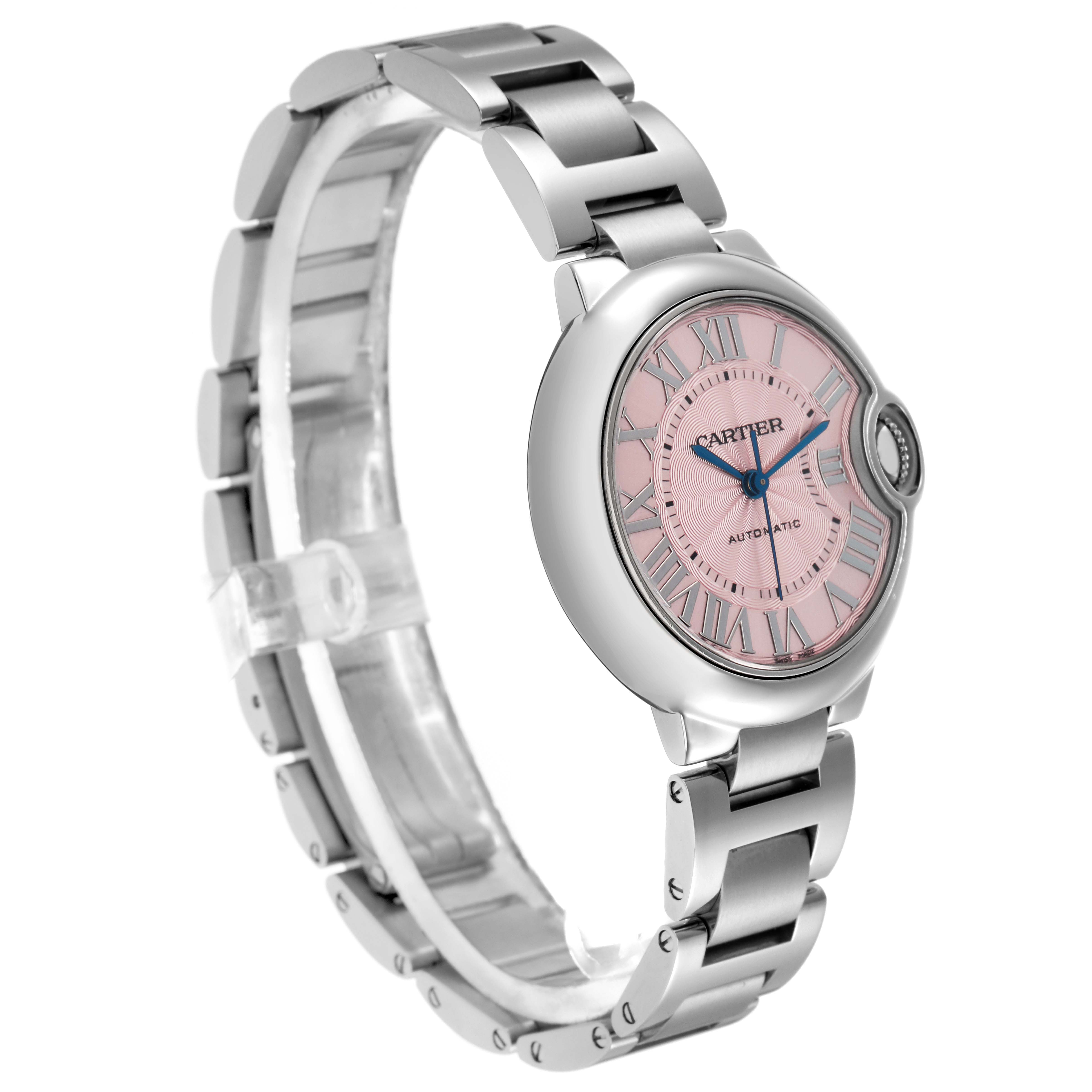 The Cartier Ballon Bleu W6920100 Women
s Stainless Steel Pink Dial W6920100 Women
s Stainless Steel Pink Dial watch is shown at a three-quarter angle, highlighting the pink dial, blue hands, and metal bracelet.
