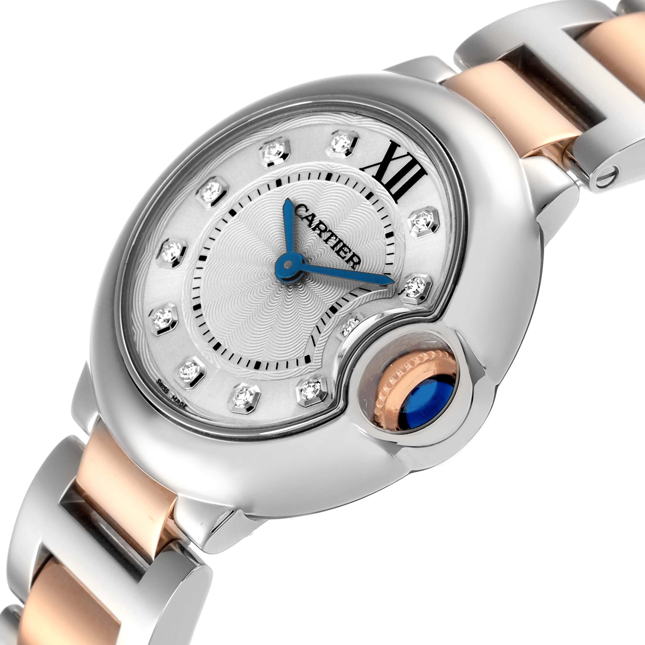 The image shows a close-up of the Cartier Ballon Bleu WE902030 Women
s Steel and Gold (two tone) Silver Dial WE902030 Women
s Steel and Gold (two tone) Silver Dial watch face, crown, and part of the bracelet at an angled view.