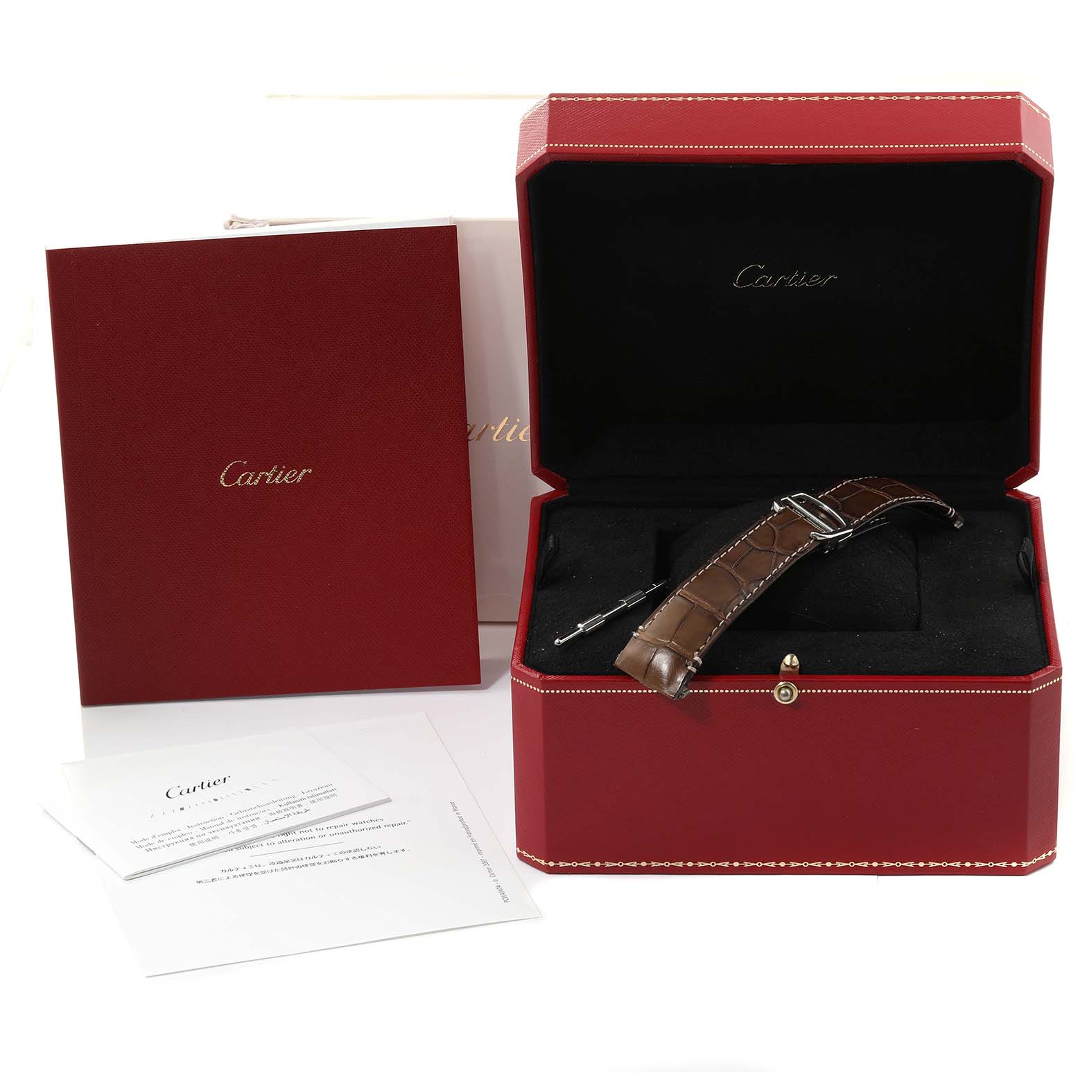 The image shows a Santos model by Cartier with the watch strap, packaging, and documentation from a slightly elevated angle.