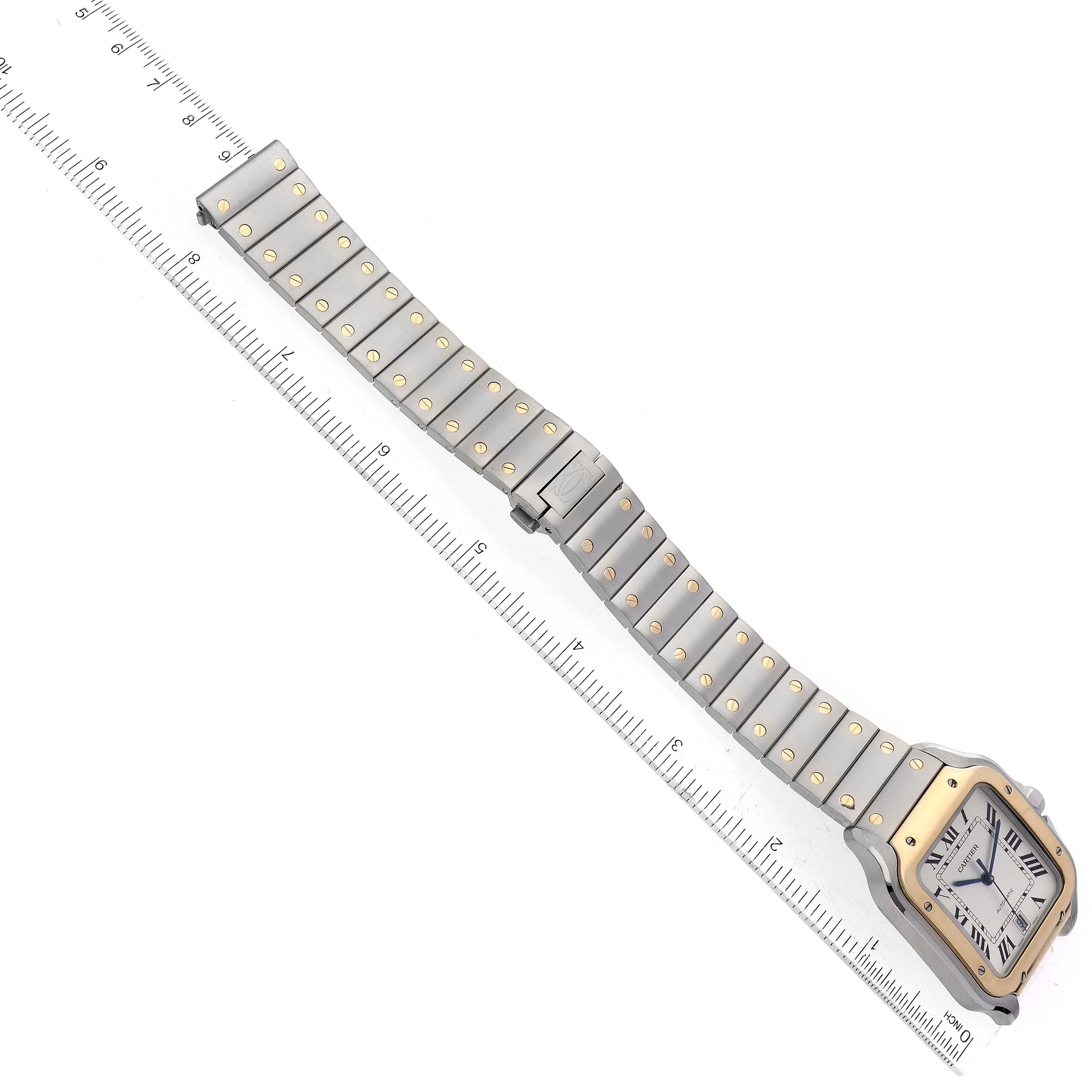 The image shows the Cartier Santos W2SA0006 Men's Steel and Gold (two tone) Silver Dial W2SA0006 Men's Steel and Gold (two tone) Silver Dial watch at a diagonal angle, displaying its full band and face against a ruler.