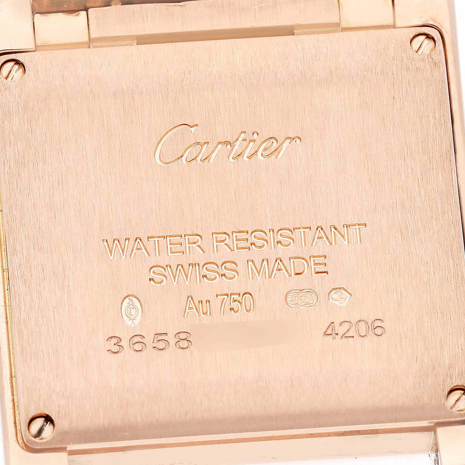 The image shows the back of a Cartier Tank Française watch, featuring engravings and branding details.