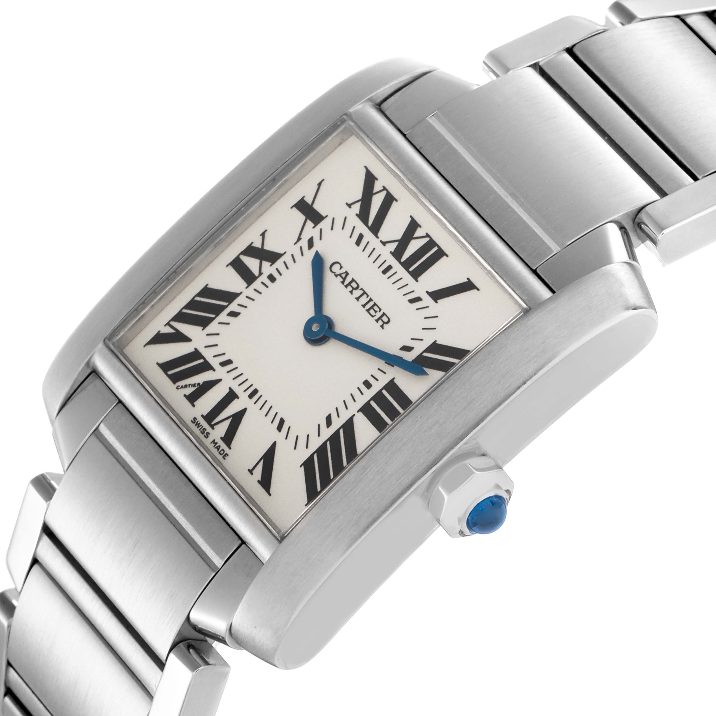 The Cartier Tank Française watch is shown from a side angle, highlighting the face, Roman numerals, bracelet, and crown with a blue gemstone.
