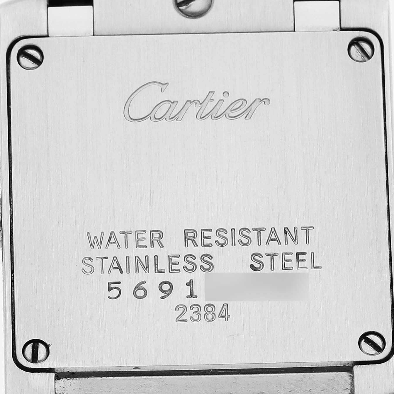 This image shows the back casing of the Cartier Tank Française, displaying markings and screws from a straight angle.