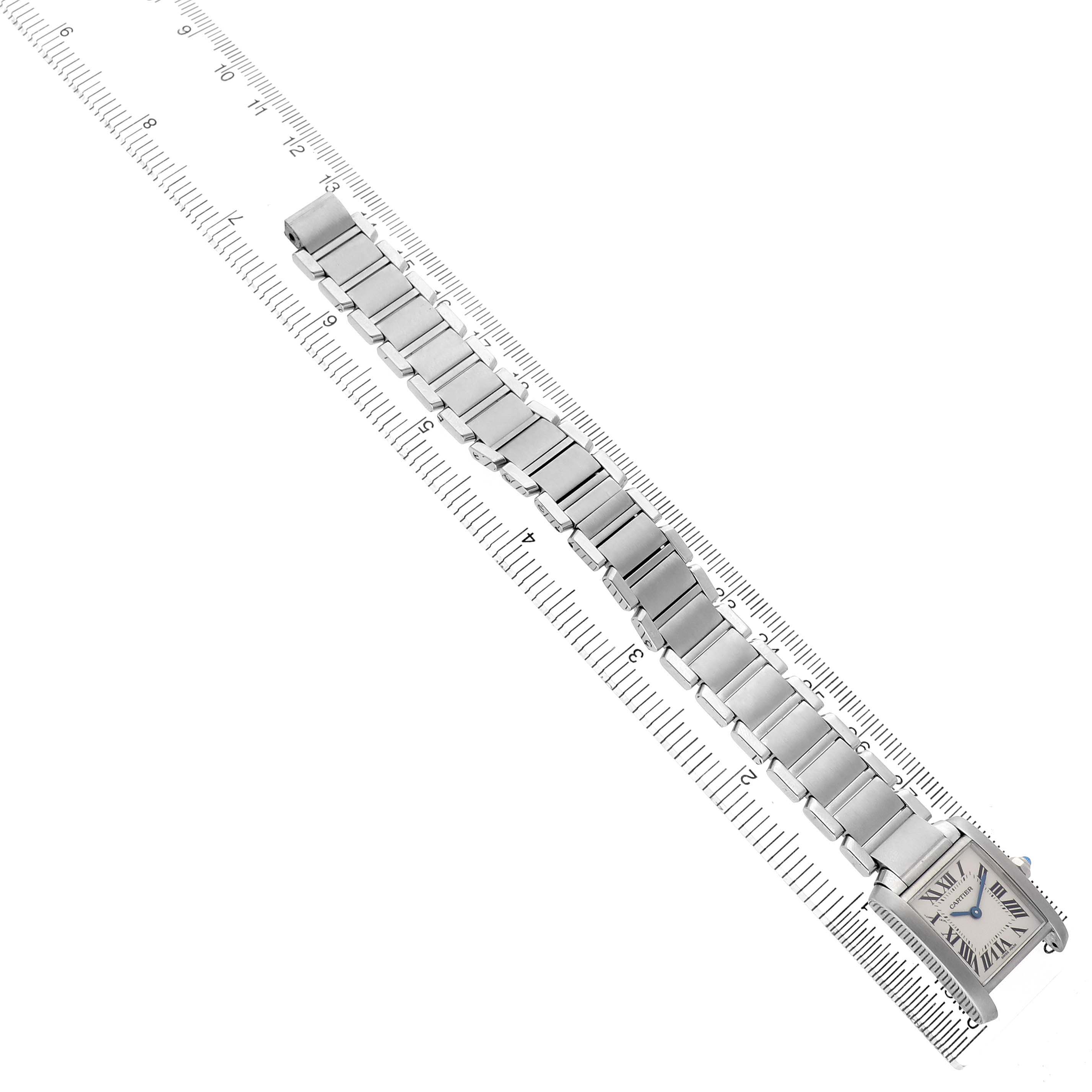 The Cartier Tank Française watch is shown from a top-down angle, displaying the band and face against a ruler.