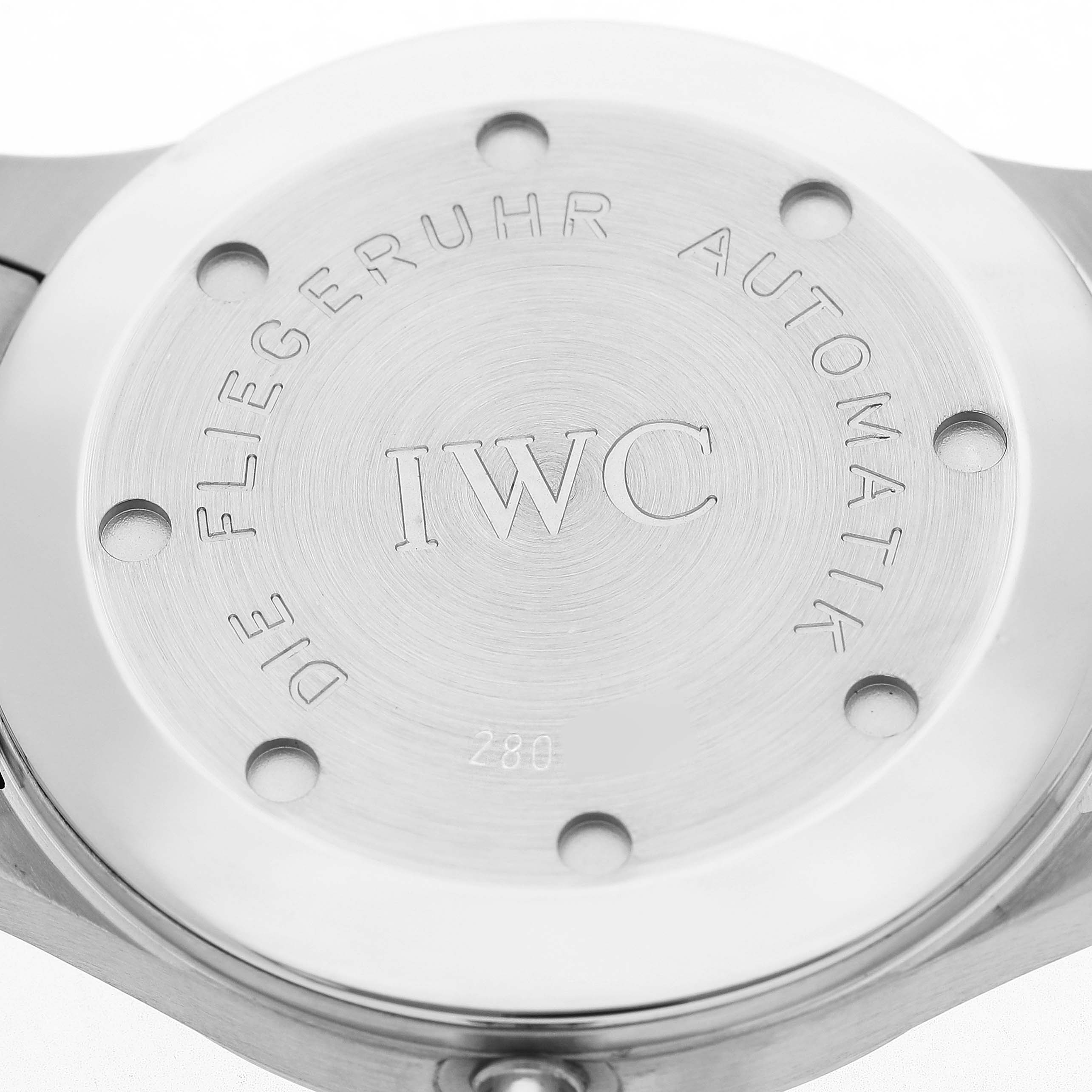 The image shows the back case of an IWC Pilot IW3253-07 Men's Stainless Steel Black Dial model watch, highlighting the engraving and screw placement.