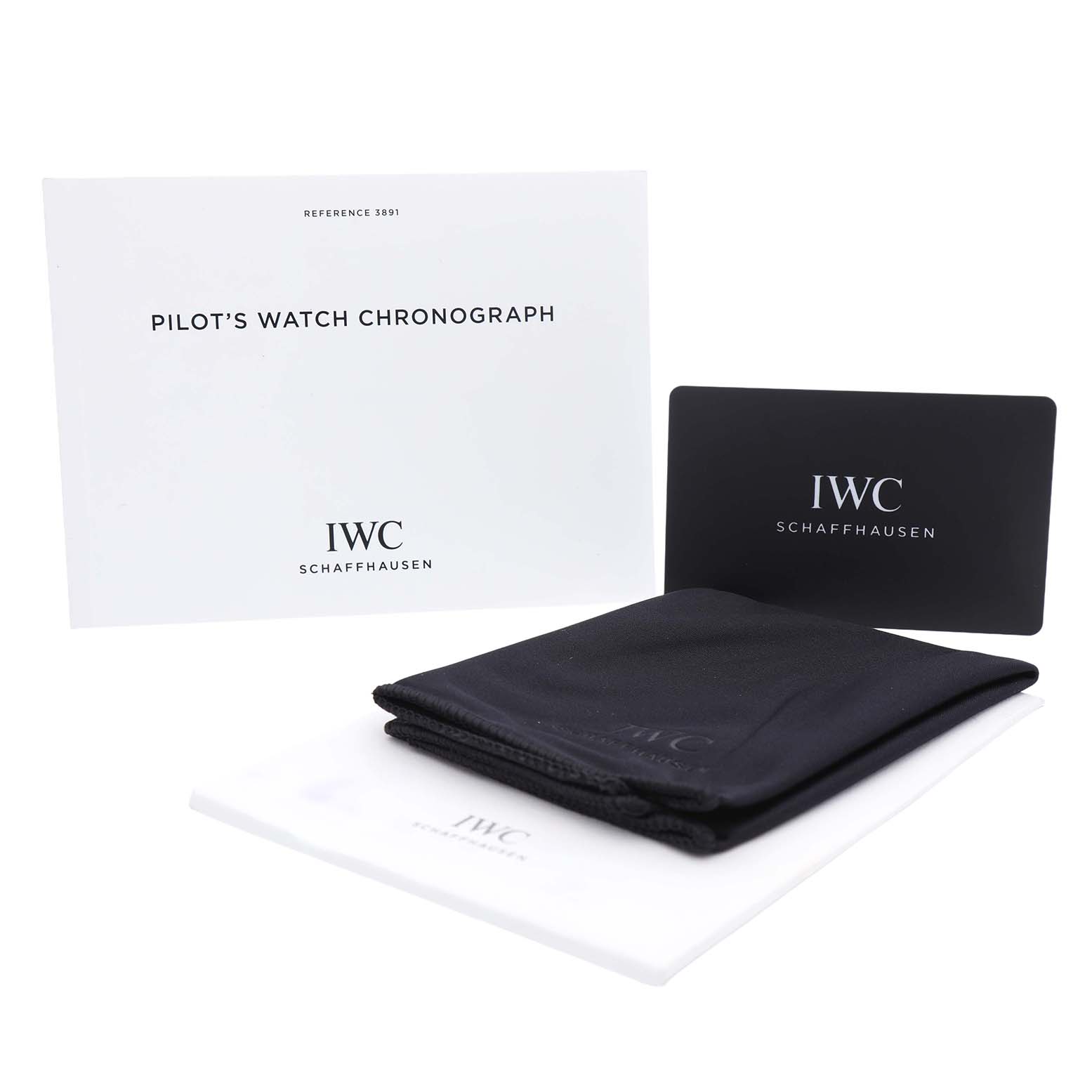 The image shows IWC Pilot IW389106 Men's Ceramic Green Dial’s Watch accessories, including a manual, a card, and cloths, displayed from a front angle.