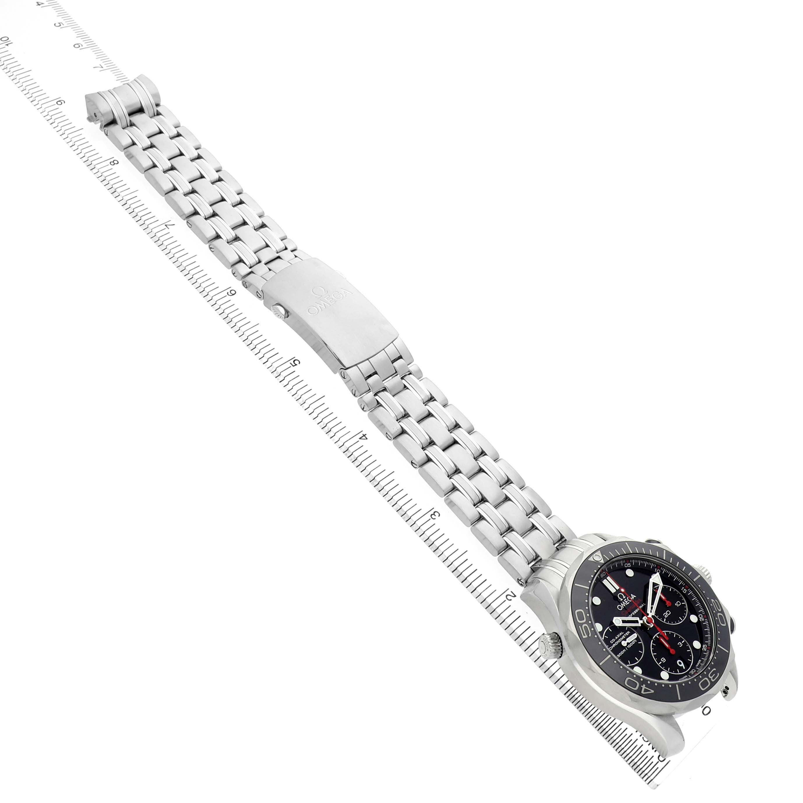 The image shows an Omega Seamaster 212.30.42.50.01.001 Men's Stainless Steel Black Dial watch at an overhead angle, highlighting the dial, bezel, and metal bracelet with a ruler alongside.
