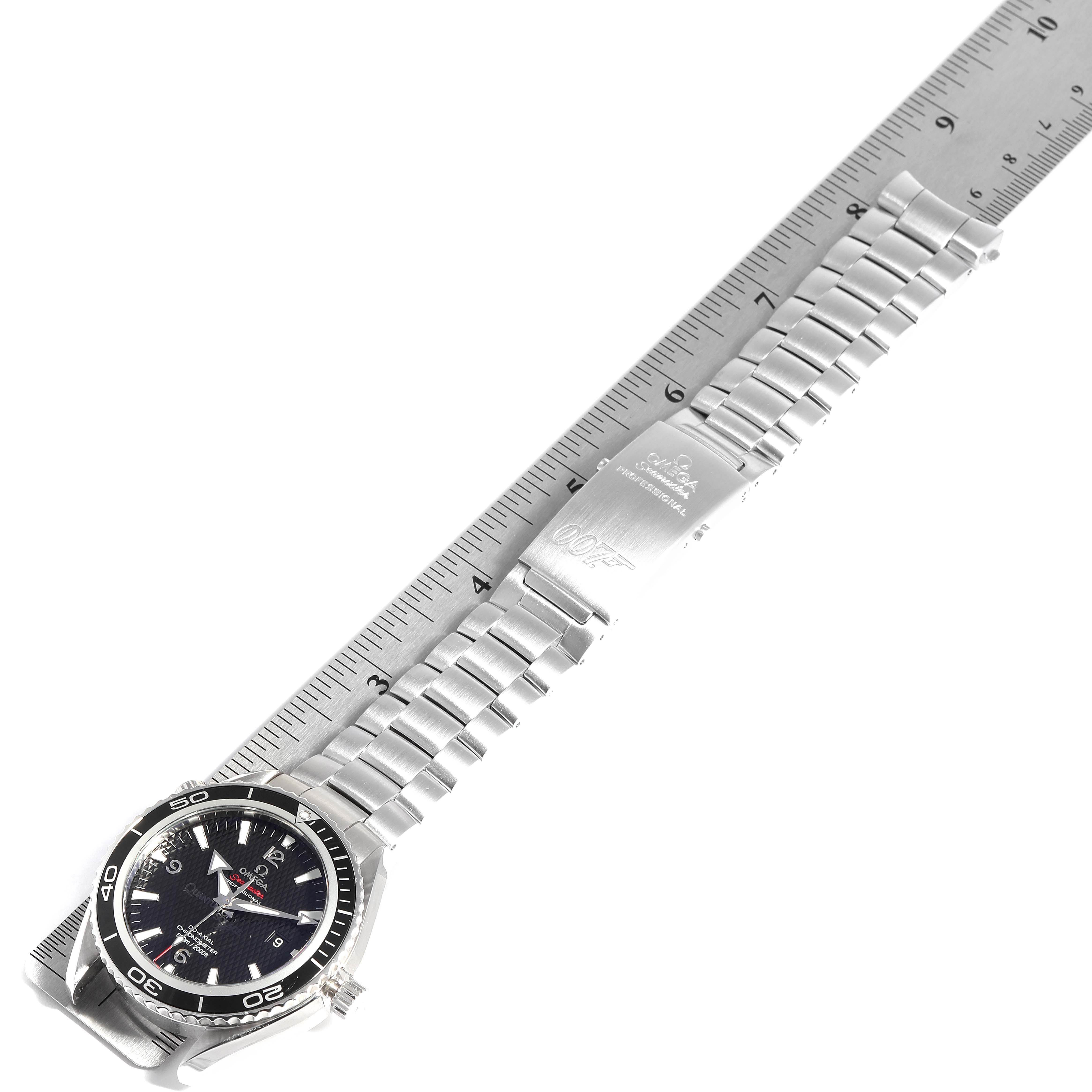 The Planet Ocean Omega watch is shown from a top-down angle with its face, bezel, bracelet, and clasp visible next to a ruler.