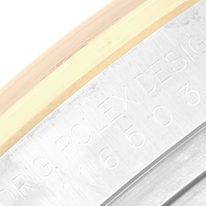 This image shows a close-up of the outer rim of a Rolex Daytona 116503 Men's Steel and Gold (two tone) Champagne Dial 116503 Men's Steel and Gold (two tone) Champagne Dial watch, featuring engraved text and part of the bezel.