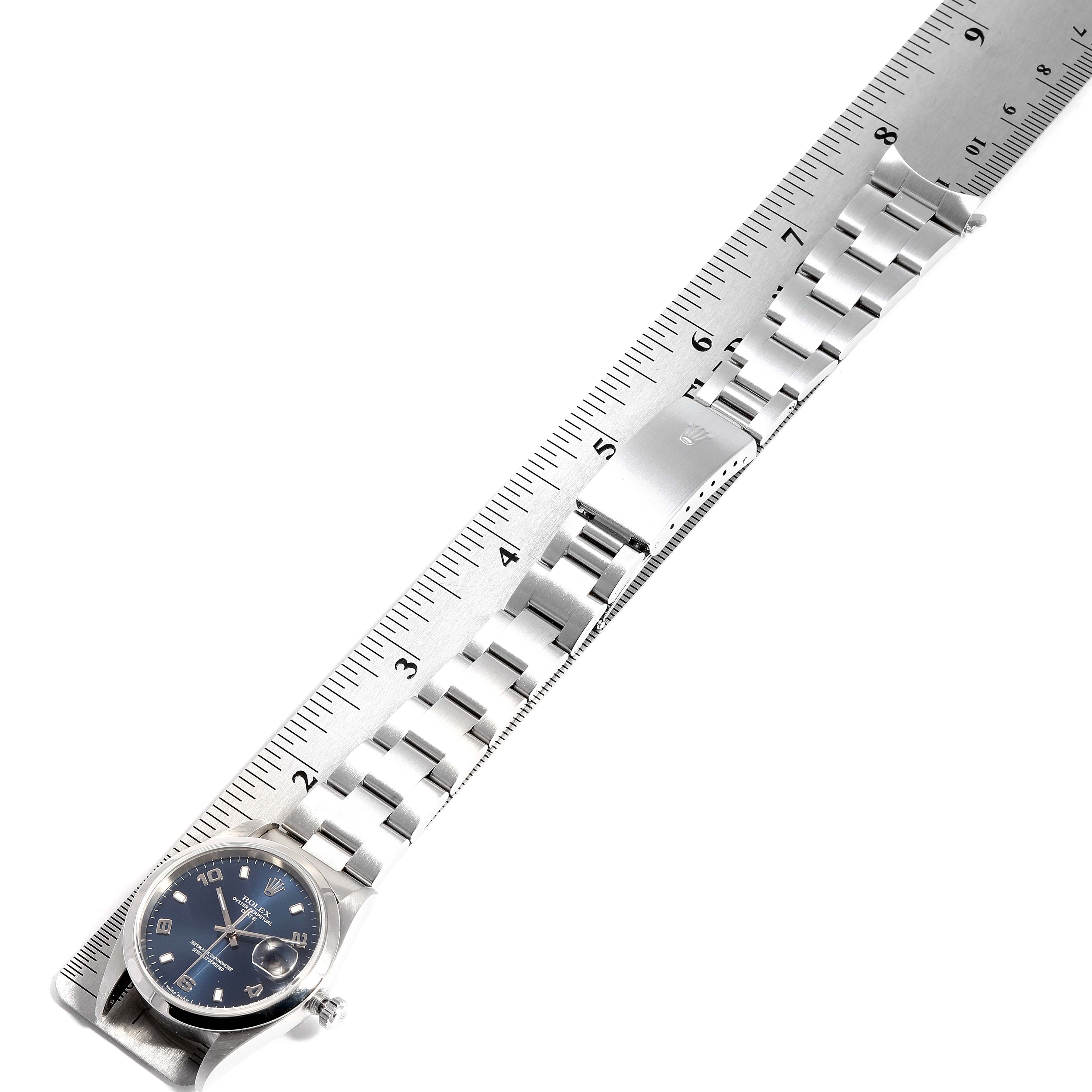 The image shows a Rolex Date 15200 Men's Stainless Steel Blue Dial 15200 Men's Stainless Steel Blue Dial model watch laid flat with a metal bracelet band against a ruler for measurement.