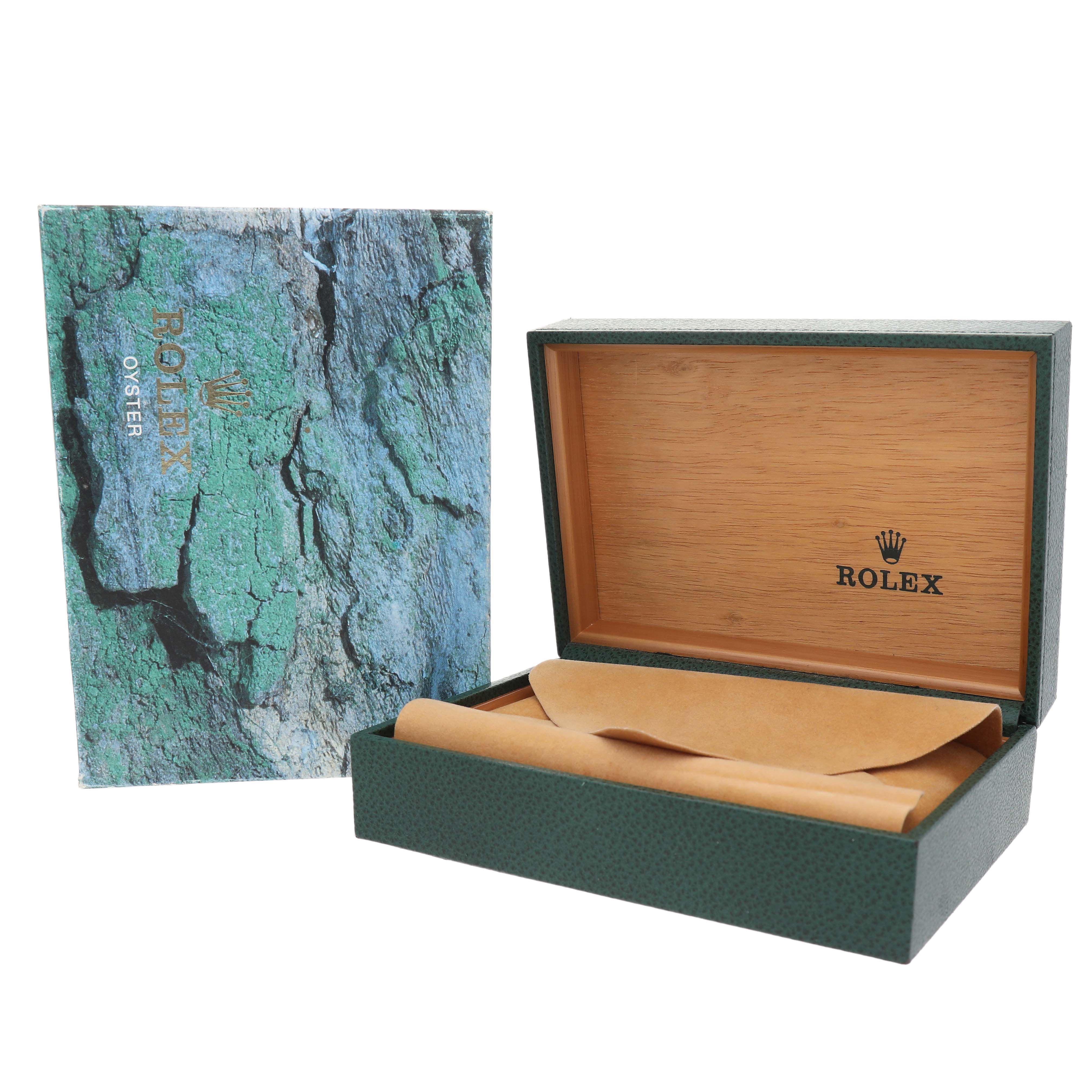 The image shows a Rolex Date 15210 Men's Stainless Steel Black Dial model watch box with its lid open and a textured outer cover.