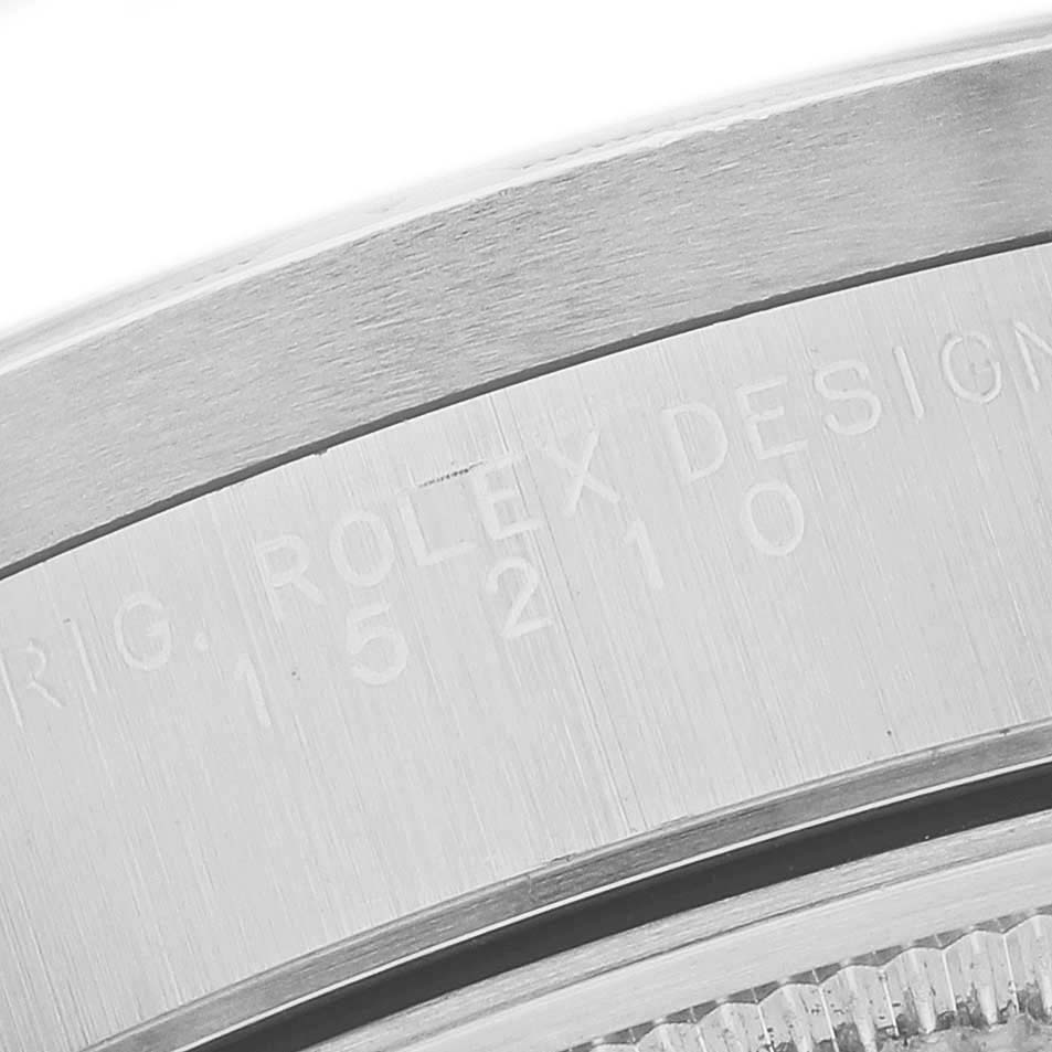 The image shows a close-up of the side of a Rolex Date 15210 Men's Stainless Steel Black Dial watch, focusing on the engraved serial and design numbers.