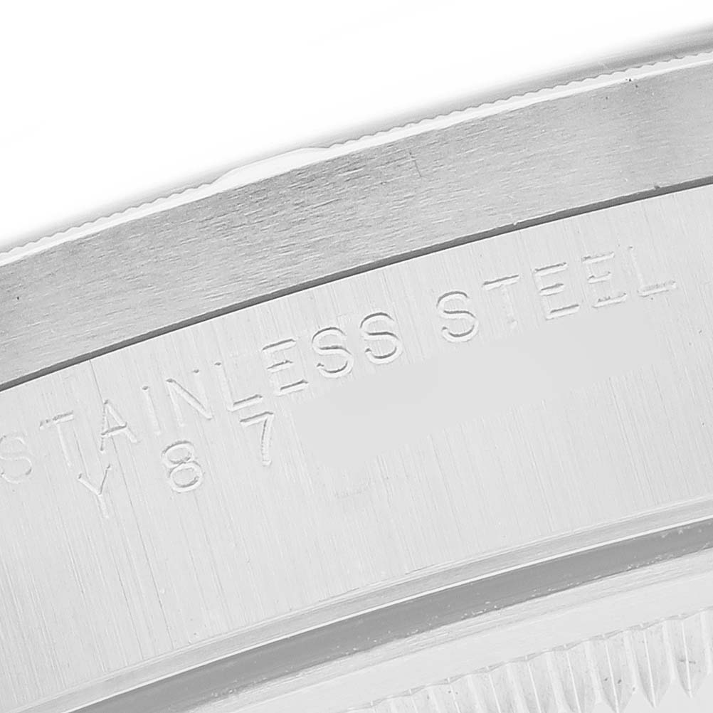 The image shows a close-up of the engraved edge on the back case of a Rolex Date 15210 Men's Stainless Steel Black Dial model watch.
