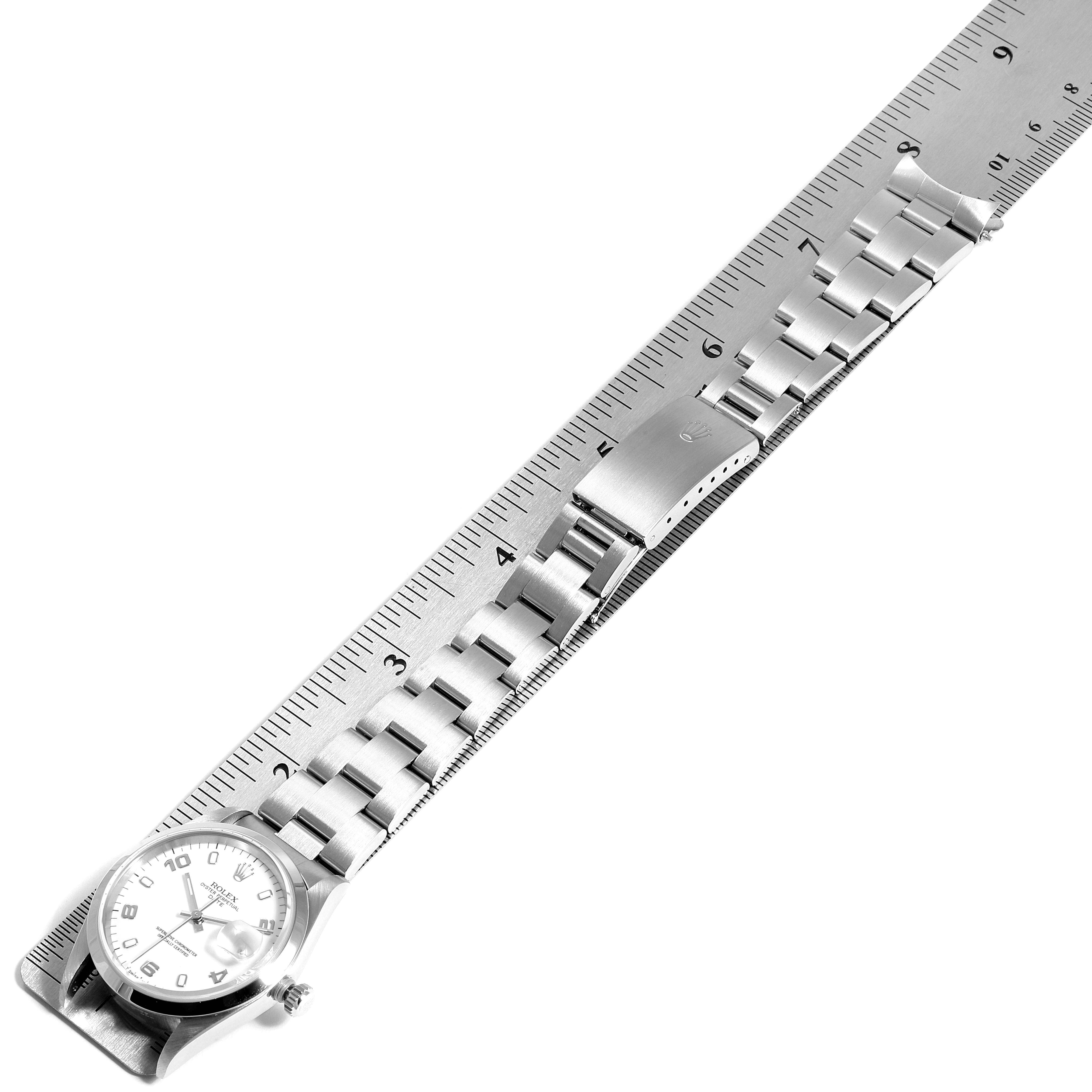 The image shows the Rolex Date 15200 Men's Stainless Steel White Dial 15200 Men's Stainless Steel White Dial watch at an overhead angle, displaying its face, bracelet, and clasp alongside a ruler for scale.