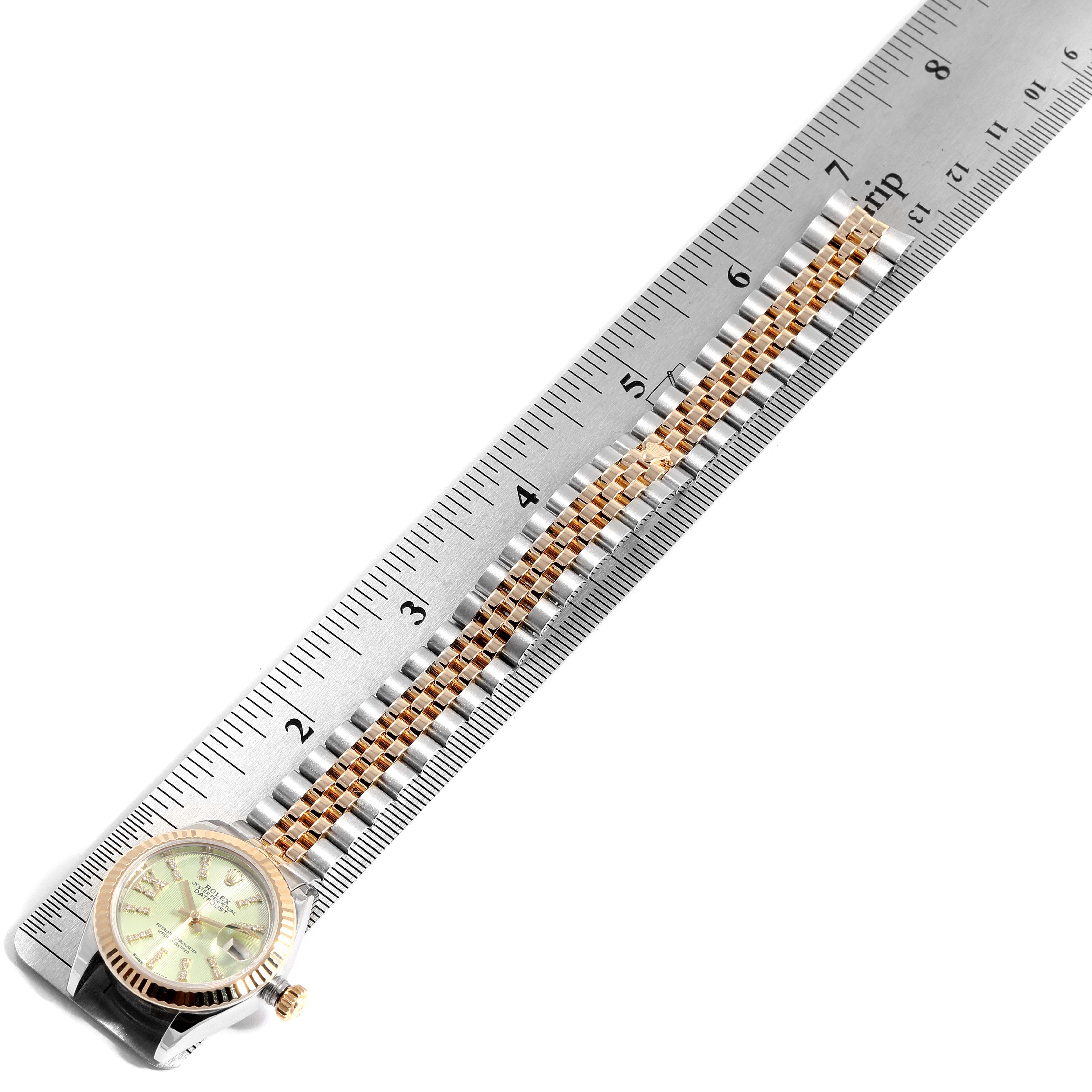 The image shows the Rolex Datejust 279173 Women's Steel and Gold (two tone) Green Dial 279173 Women's Steel and Gold (two tone) Green Dial watch laid flat next to a ruler, showcasing its face and bracelet.