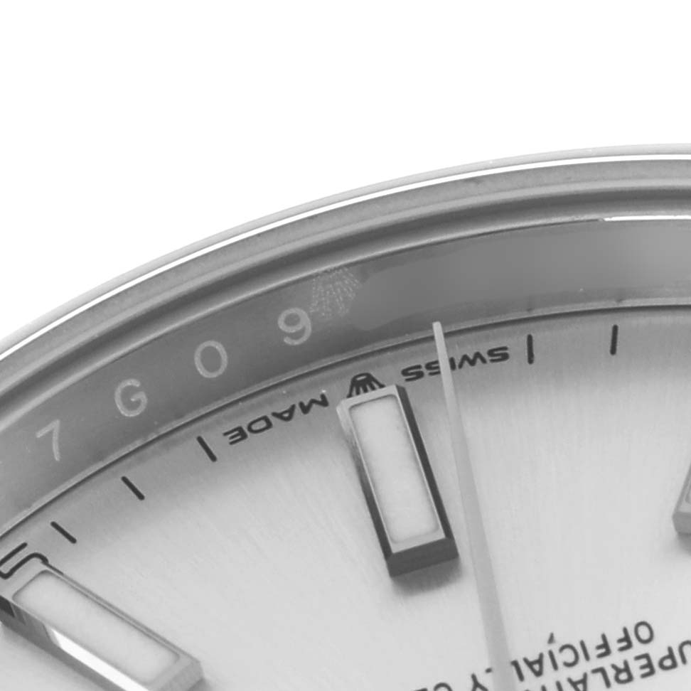 The image shows a close-up of the Rolex Datejust 126300 Men
s Stainless Steel Silver Dial 126300 Men
s Stainless Steel Silver Dial
s dial, highlighting its markers, text, and partial rehaut.