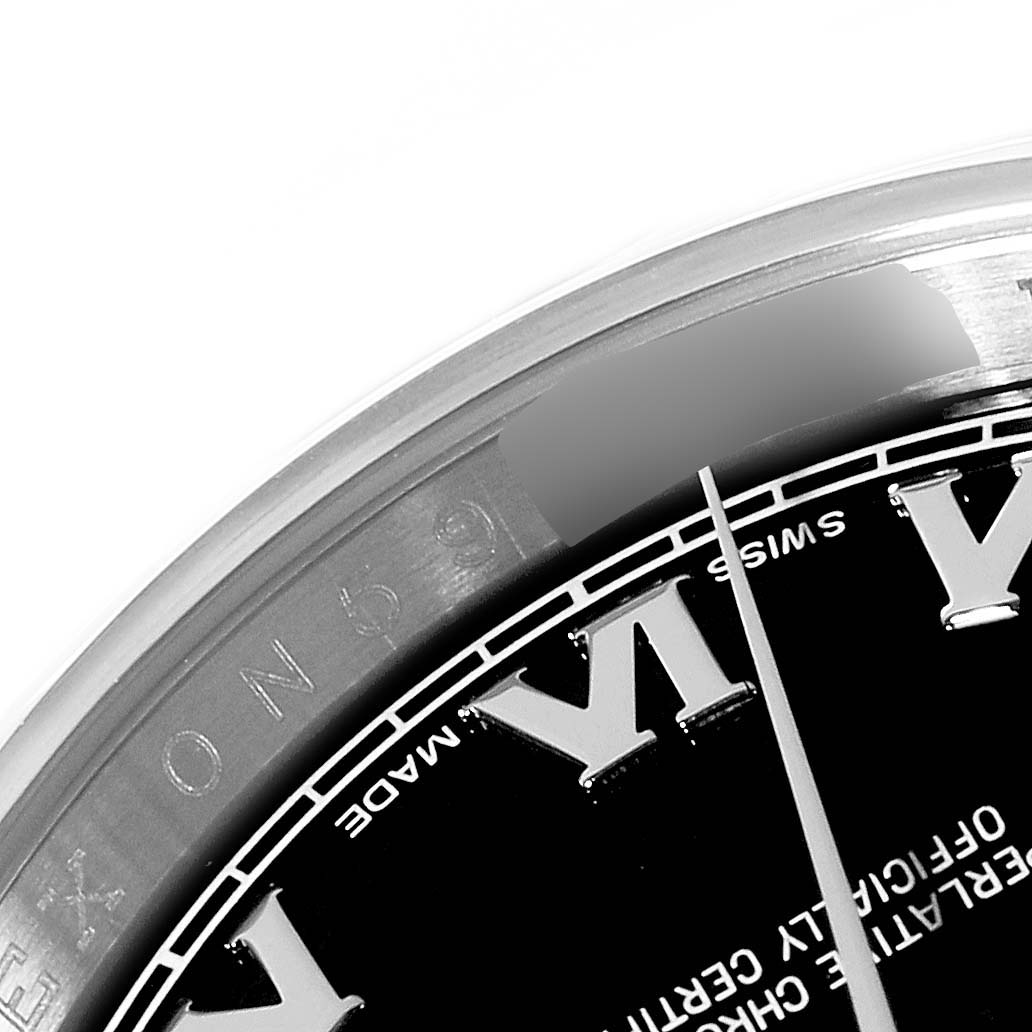 This close-up image of a Rolex Datejust 116200 Men
s Stainless Steel Black Dial 116200 Men
s Stainless Steel Black Dial watch shows part of the black dial with Roman numerals and a portion of the bezel.