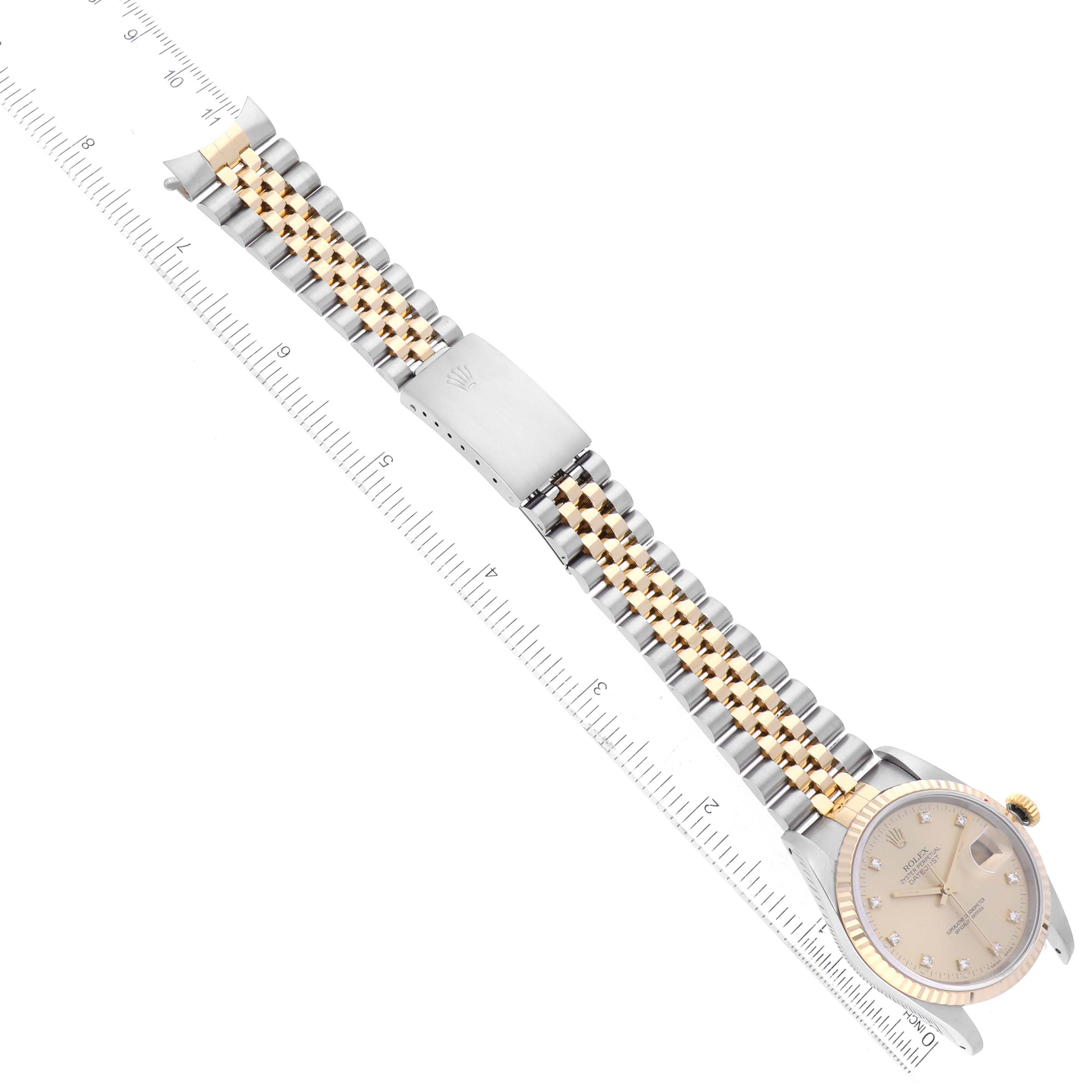 The image shows a Rolex Datejust 16233 Men's Steel and Gold (two tone) Champagne Dial 16233 Men's Steel and Gold (two tone) Champagne Dial watch lying flat with its face, bezel, Jubilee bracelet, and clasp visible along with a ruler for scale.