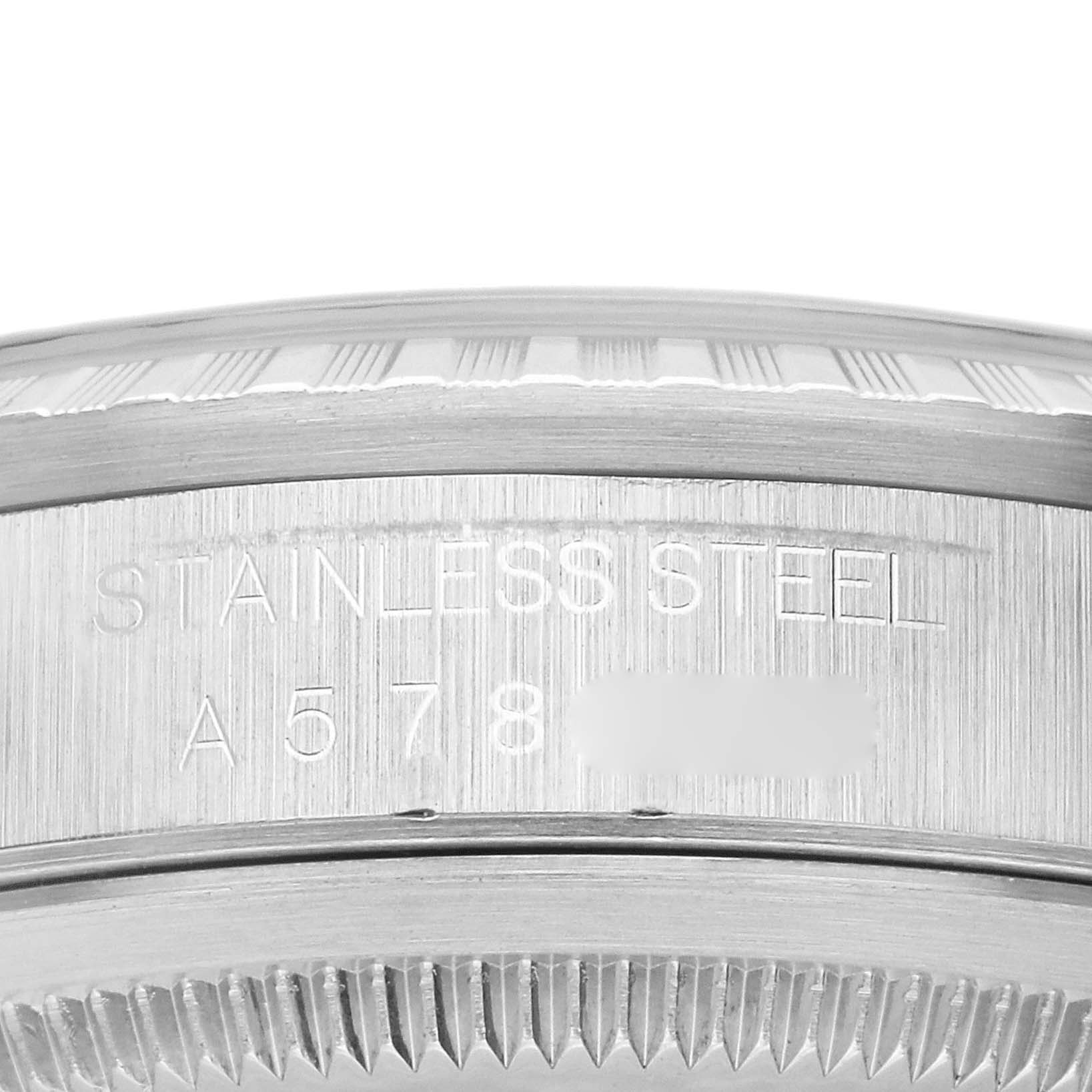 This is a close-up shot of the Rolex Datejust 16220 Men's Stainless Steel Black Dial 16220 Men's Stainless Steel Black Dial watch case showing the engraved serial number and "STAINLESS STEEL" inscription.