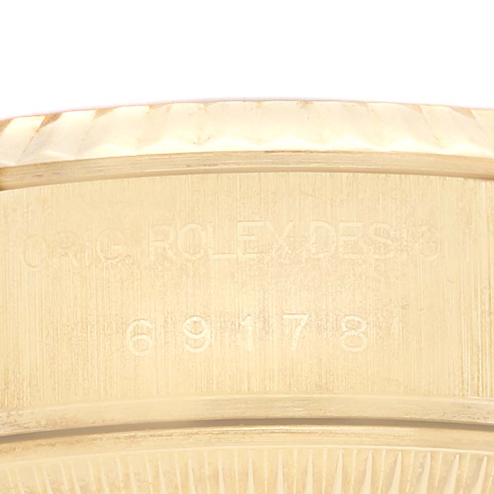 Close-up view of the case side of a Rolex President 69178 Women's Yellow Gold Champagne Dial 69178 Women's Yellow Gold Champagne Dial model, showing engravings and part of the fluted bezel.