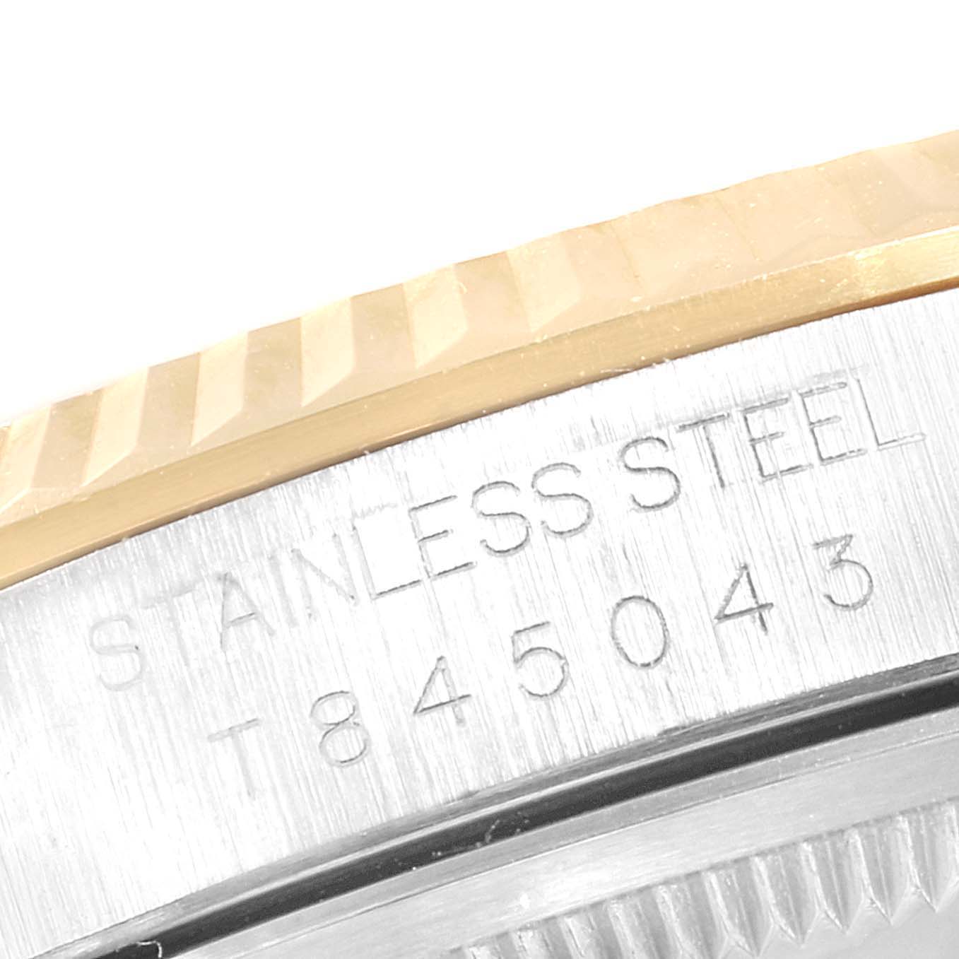 The image shows a close-up of the fluted bezel and engraved case back of the Rolex Datejust 16233 Men's Steel and Gold (two tone) Champagne Dial 16233 Men's Steel and Gold (two tone) Champagne Dial.