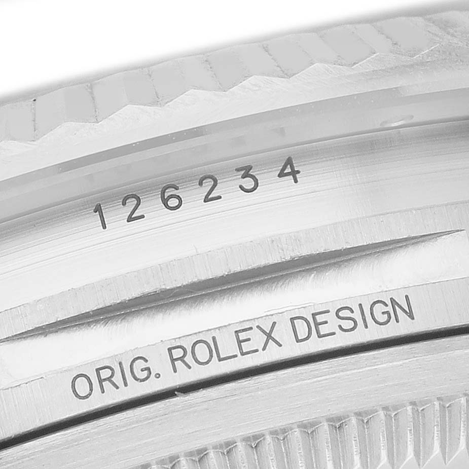 The image shows a close-up of the Datejust Rolex bezel with engraved serial numbers.